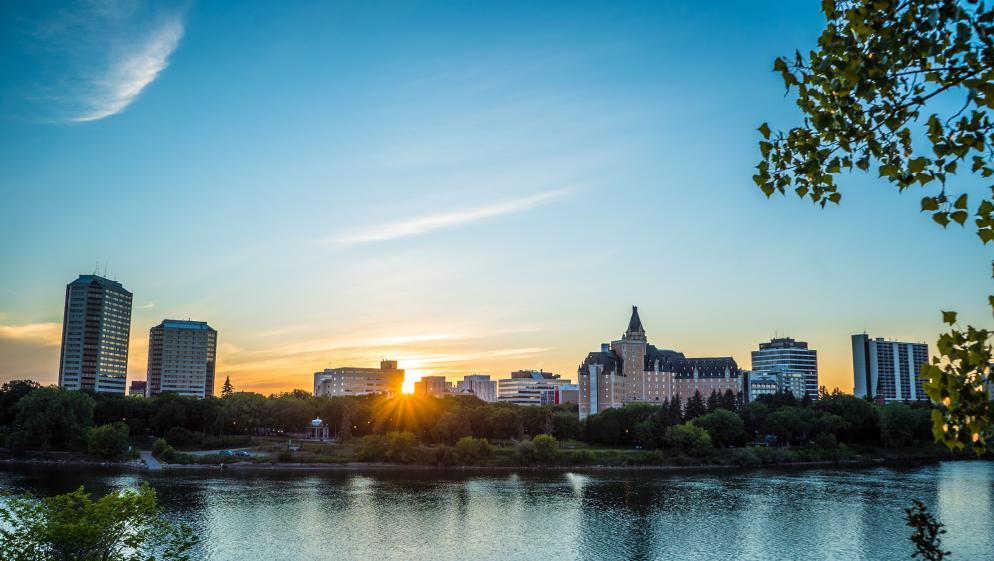 The sun rises over the water in Saskatoon