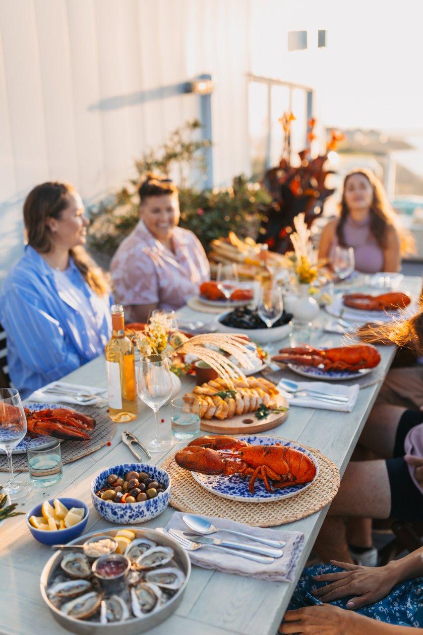 People at a long table with seafood spread in the forground