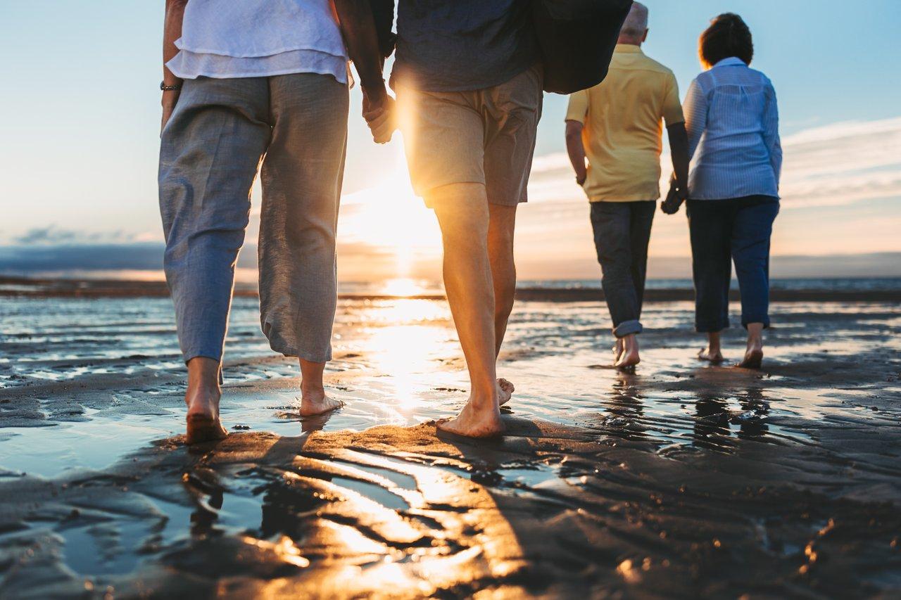 people walking in the sand at sunset