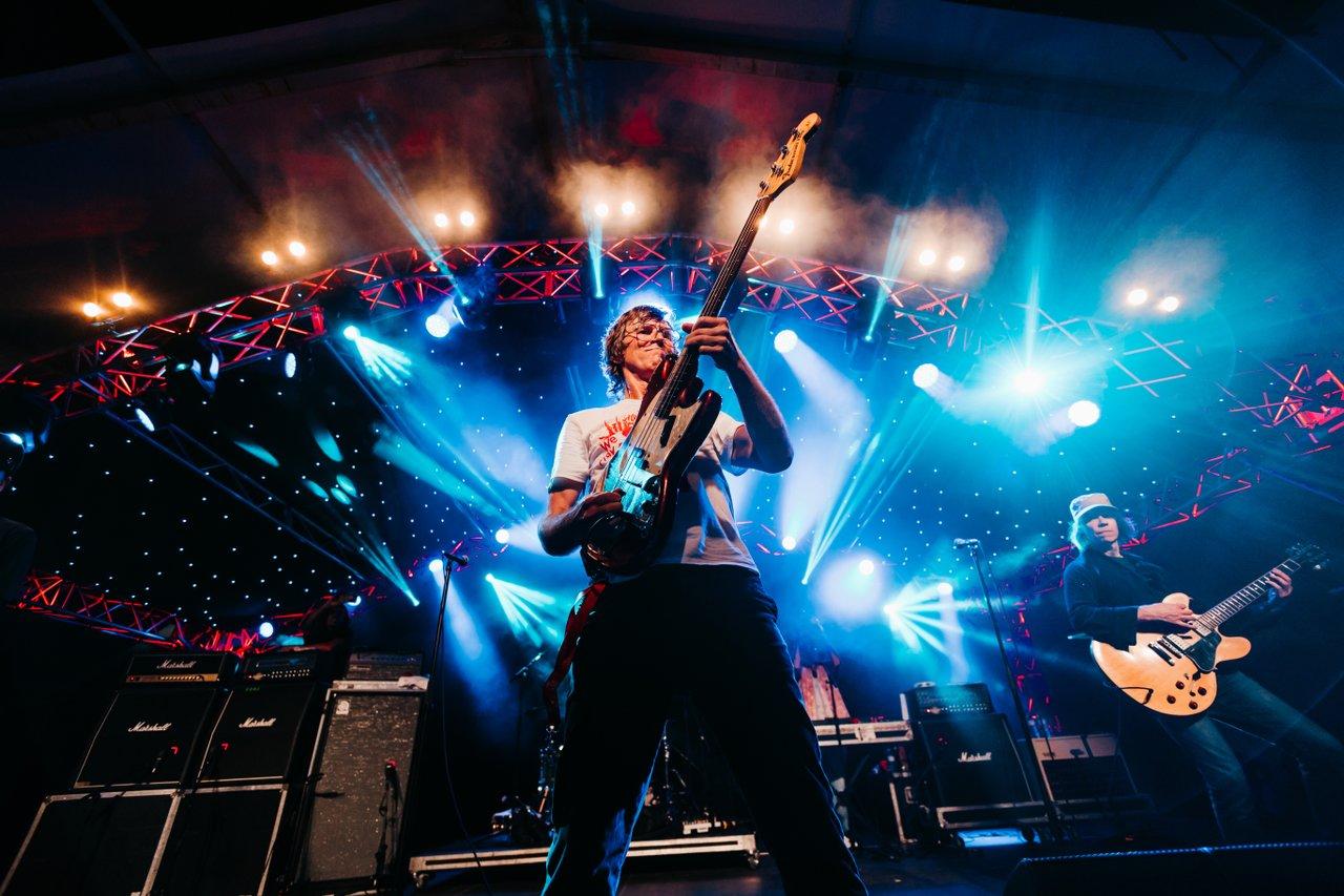 person centre stage with blue lights at a music festival 