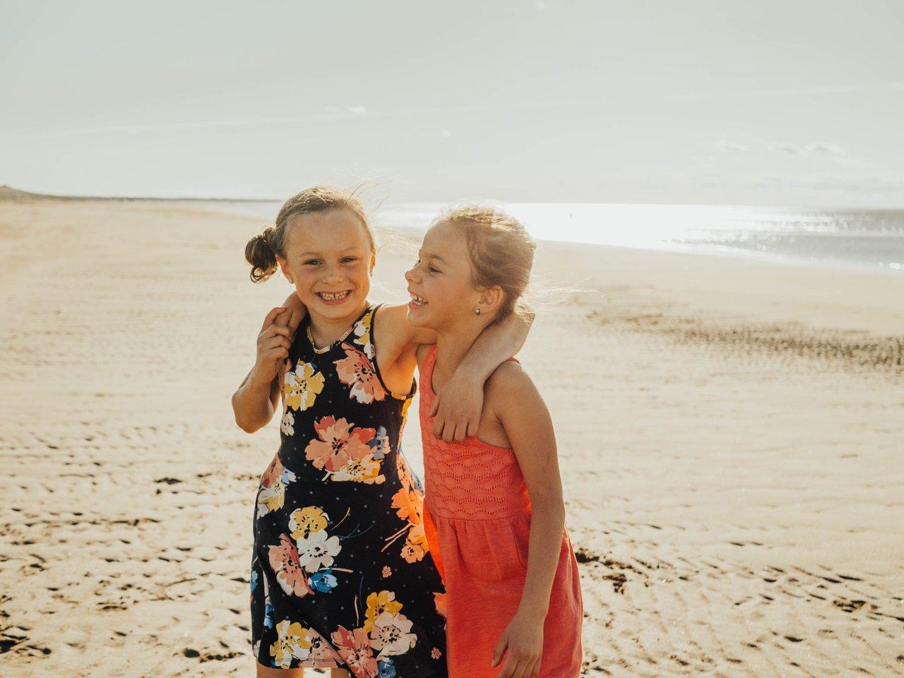 Two kids giggling in the sand