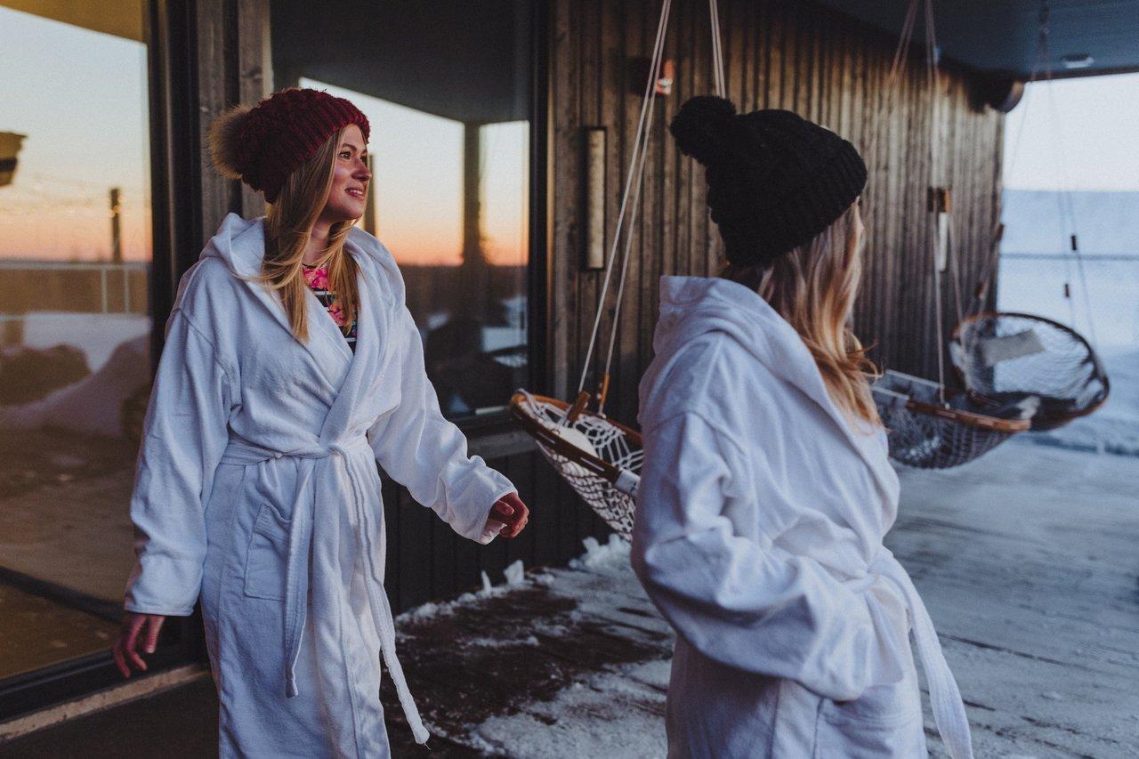 USVA spa features two people in robes and hats heading away from a building in the cold