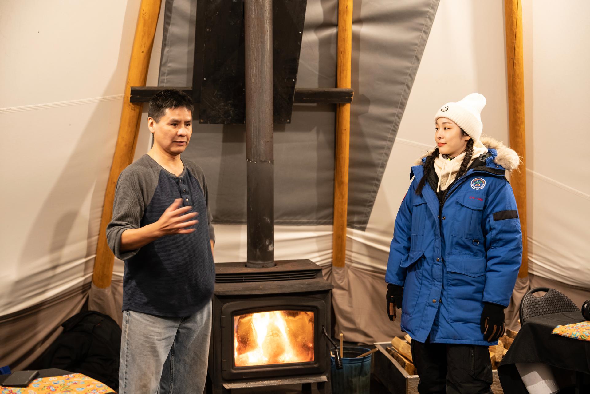 Yuna Kim inside a tent speaking with a man.