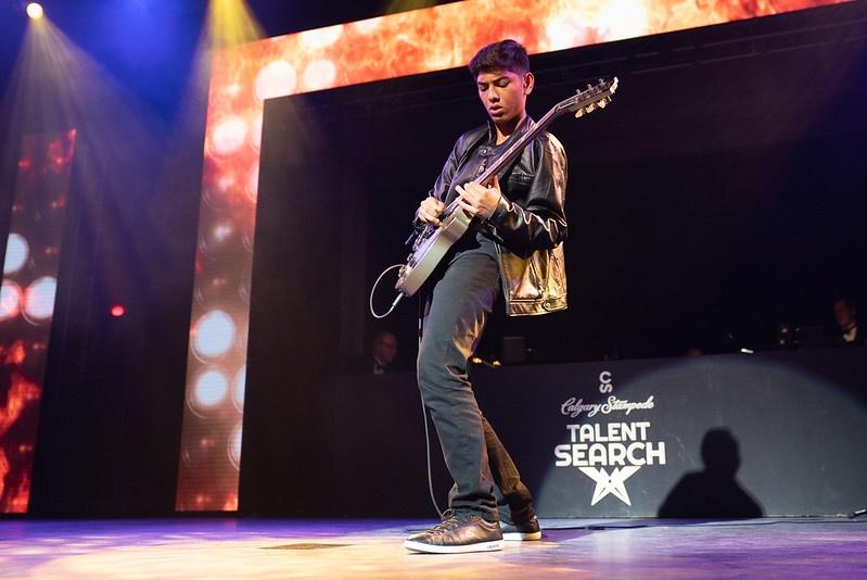 A young man plays the electric guitar on stage at the Calgary Stampede Talent Search