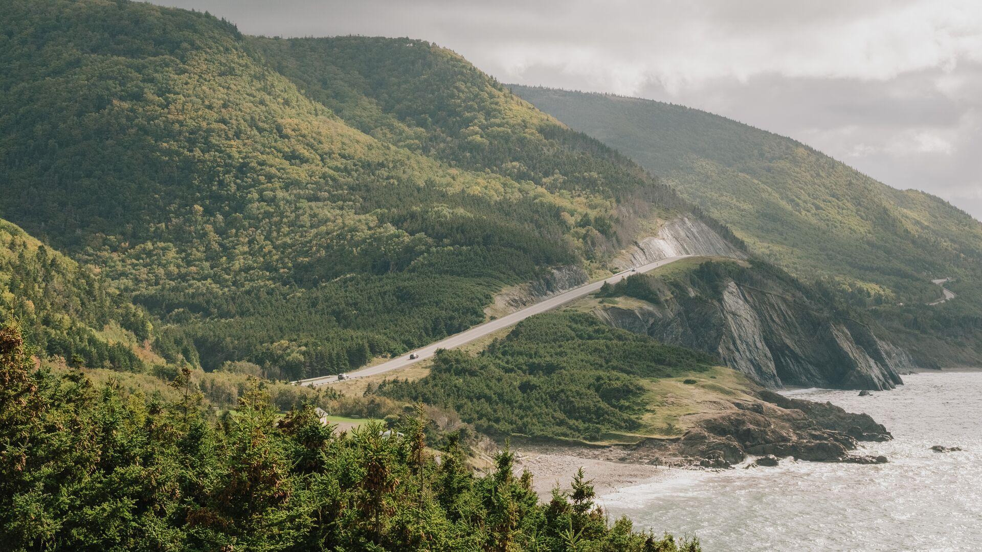 image of a road along side mountain by the water