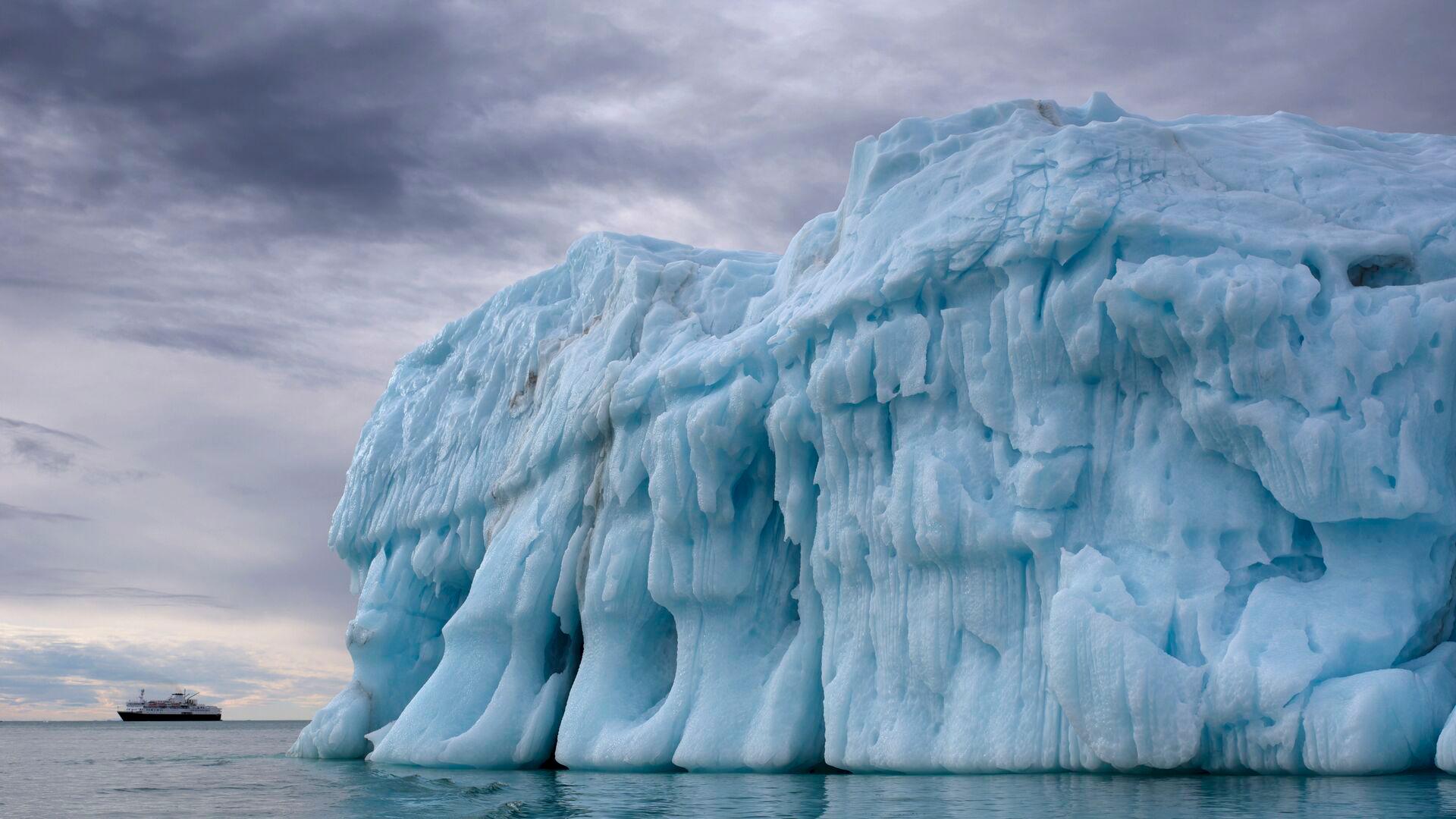 iceberg in water with grey skies