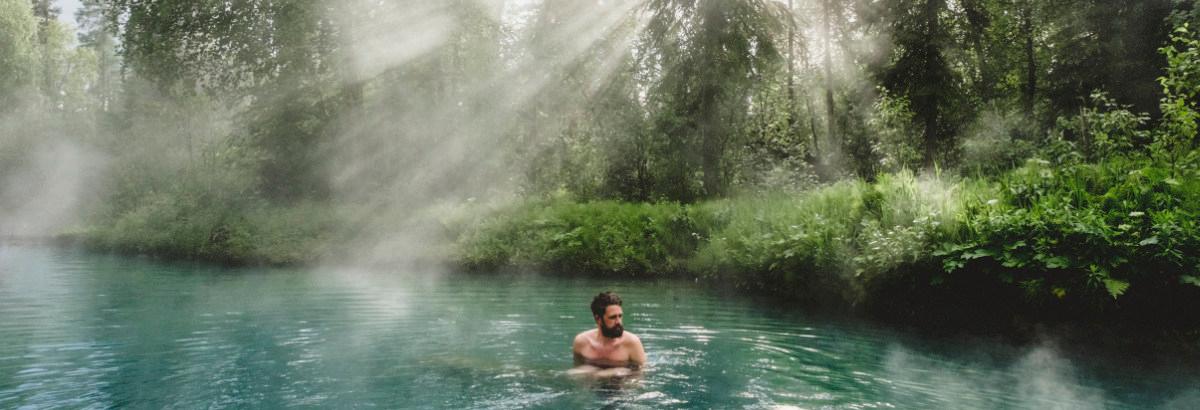 A man soaking in the Liard Hot Springs.