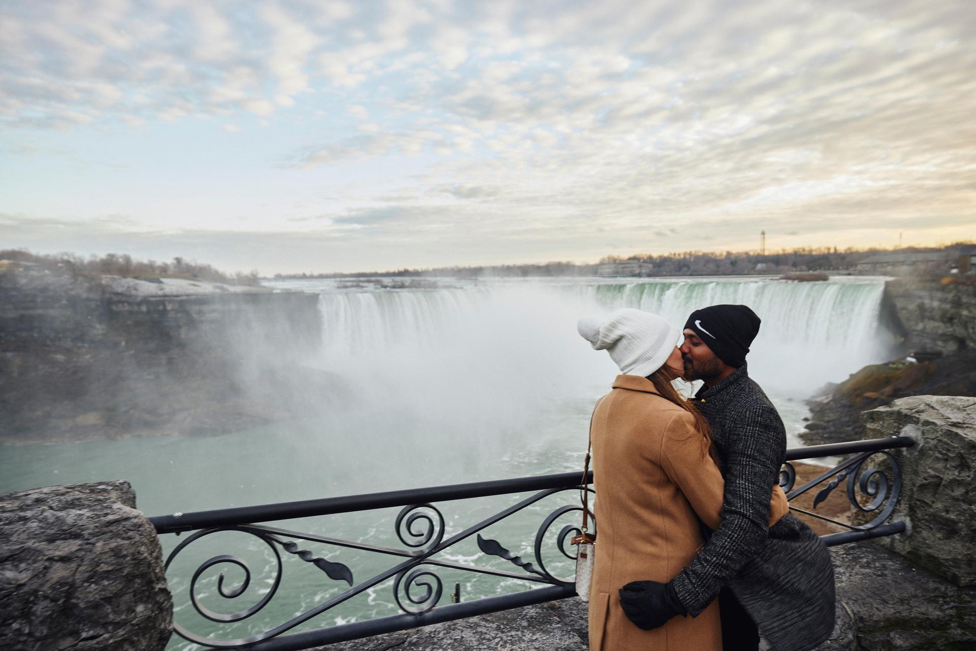 A couple kissing in front of Niagara Falls.