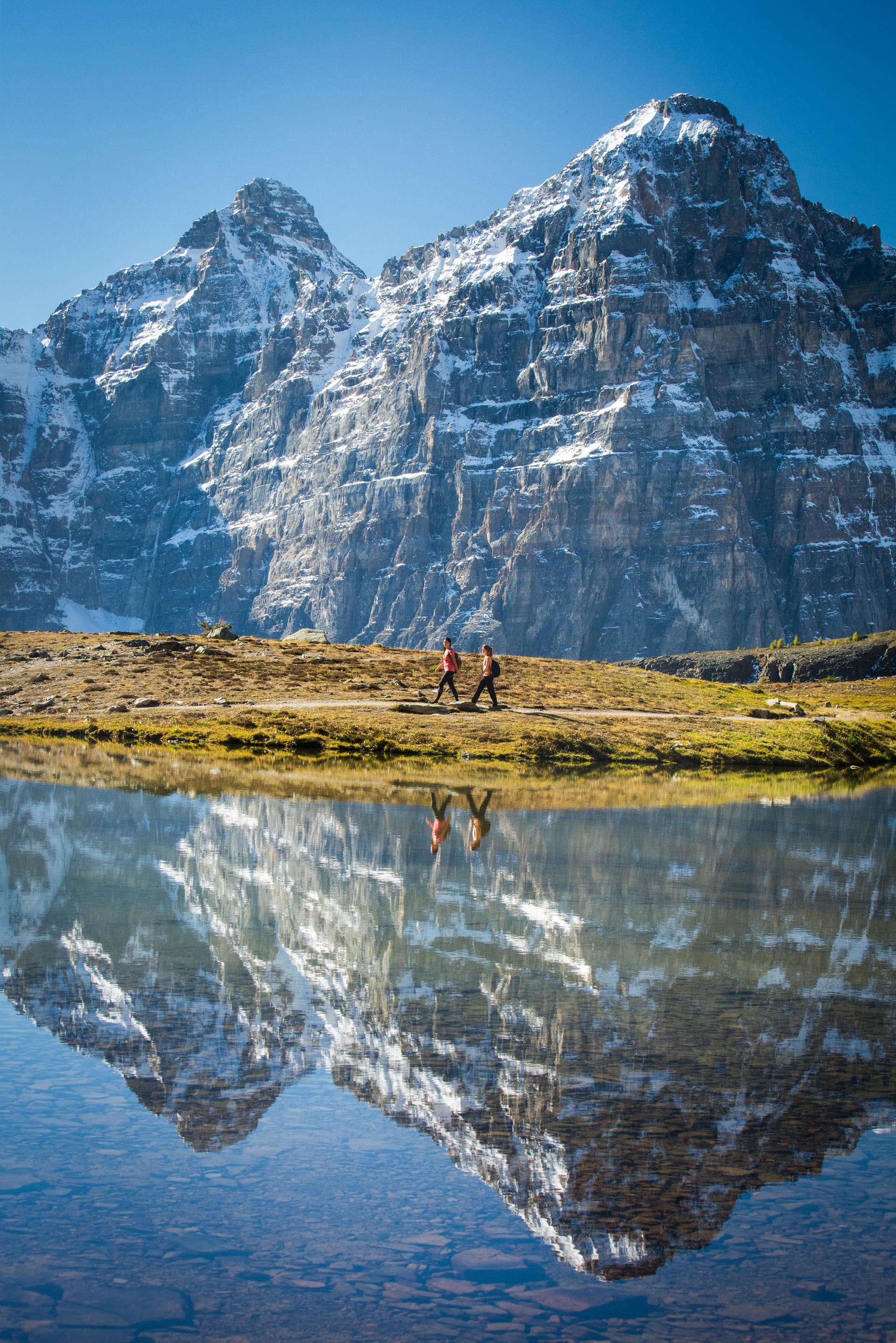 A reflective alpine lake with towering snow-capped mountains