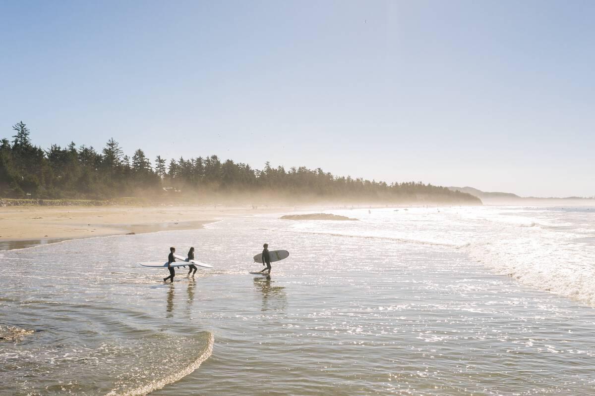 Surfers on beach in Tofino.