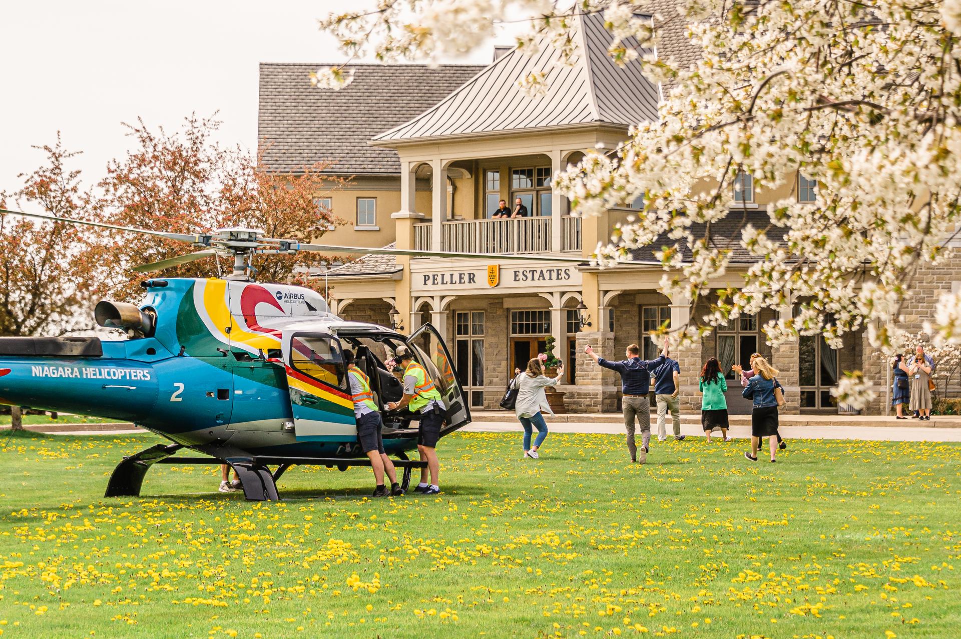 Helicopter landing at winery estate with visitors on the lawn