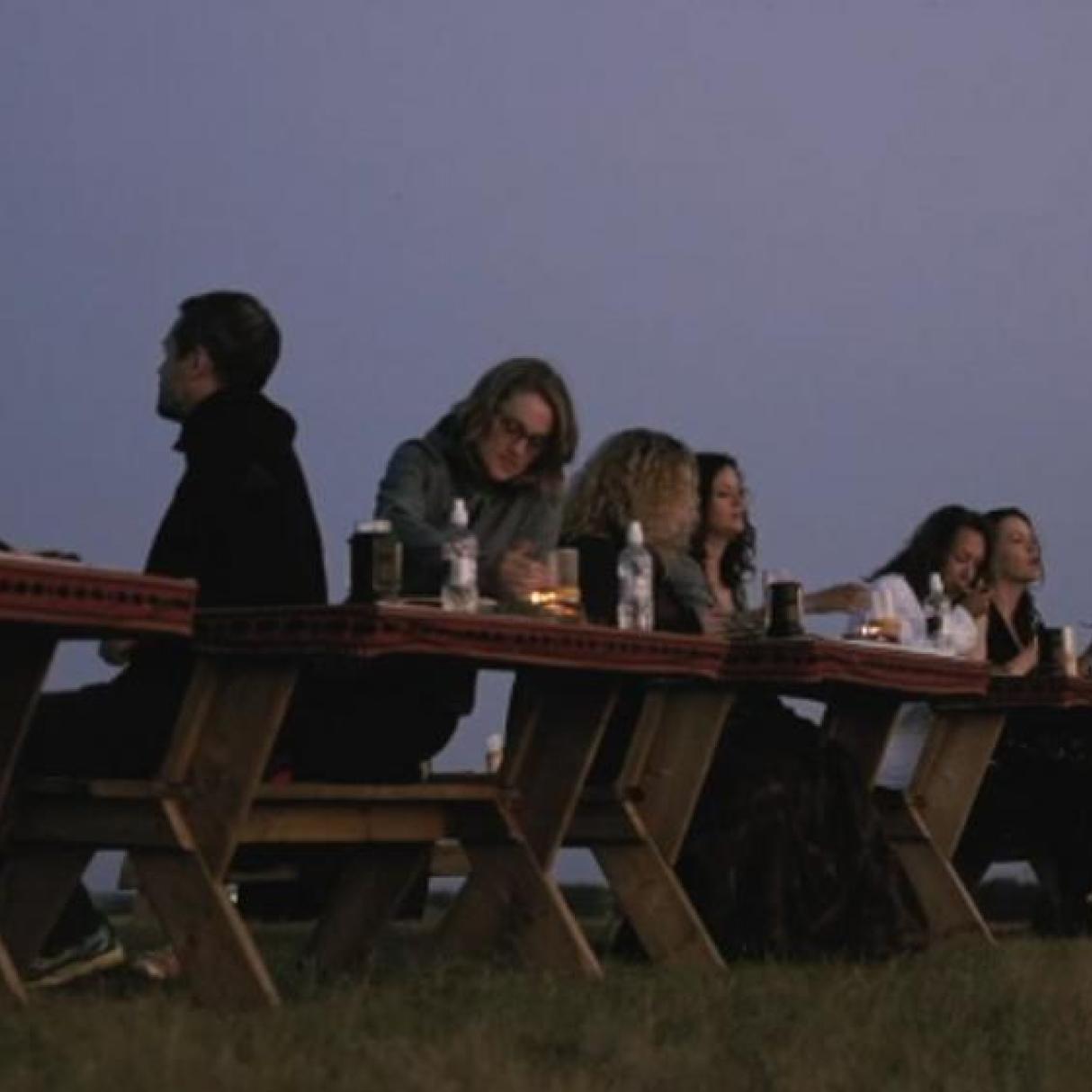People eating an outdoor dinner at dusk