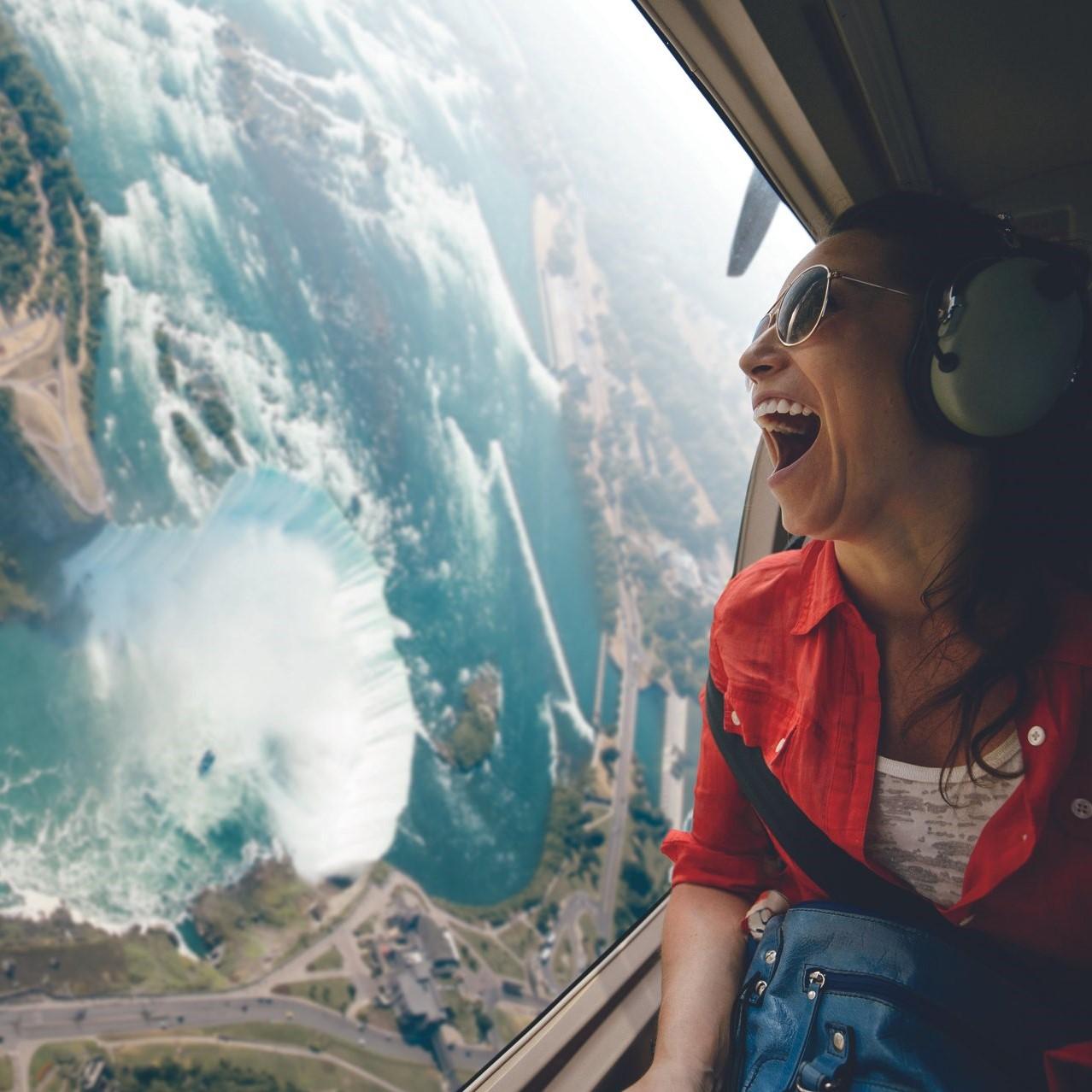 An excited traveler rides a helicopter above Niagara Falls