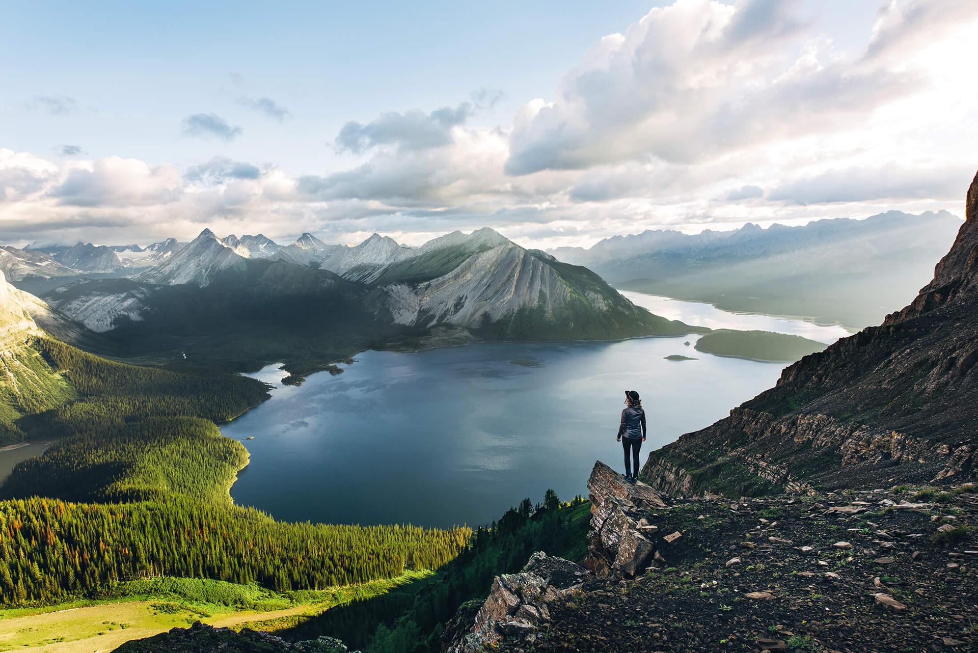 A woman standing on mountains in Canada overlooking a lake