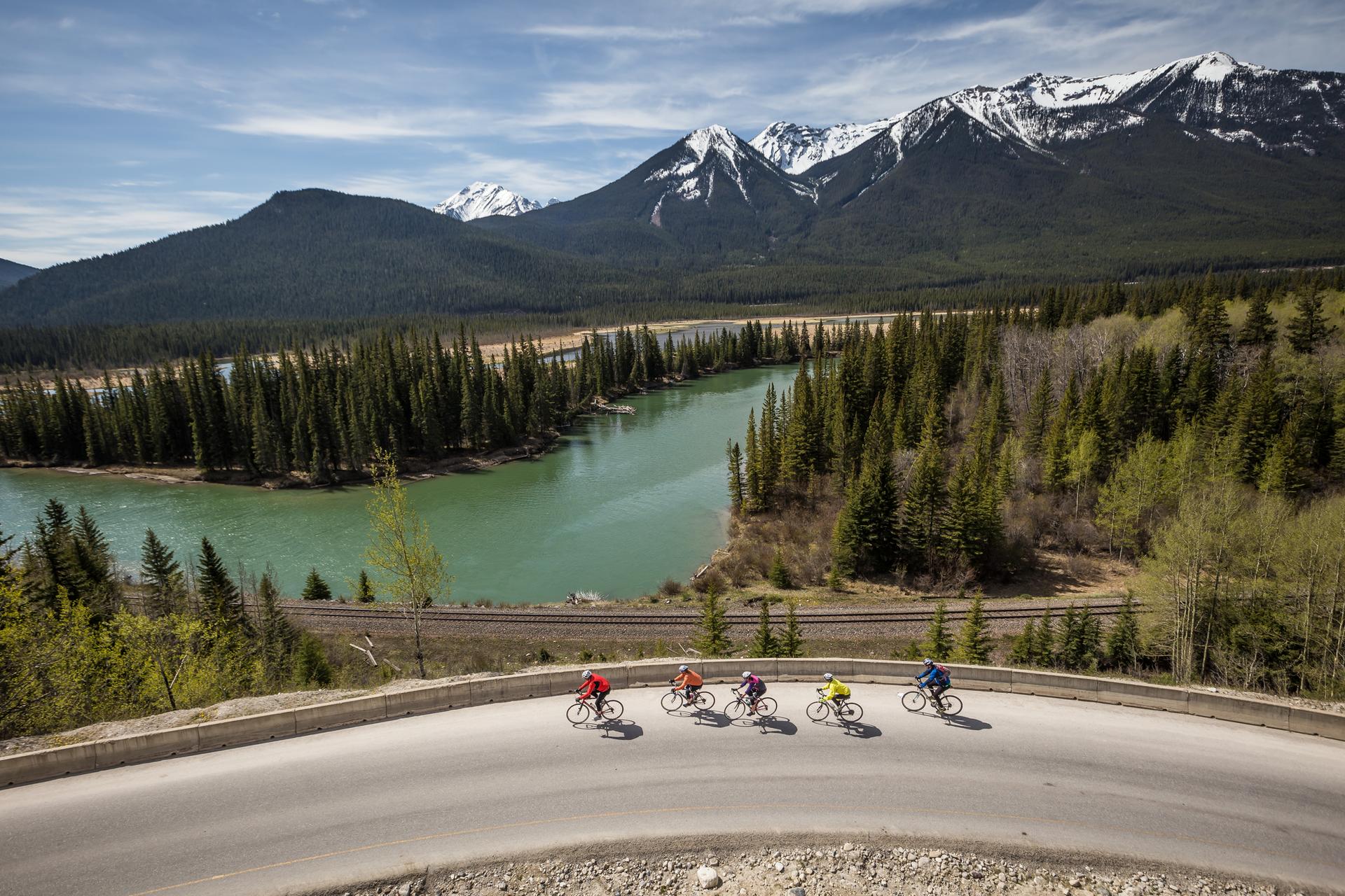 A group of cyclists travel along the icefields parkway in the Rocky mountains