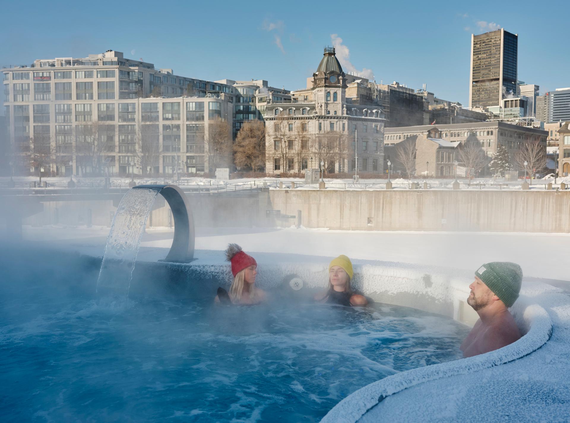 People soak in an outdoor thermal pool at Bota Bota spa in winter in the Old Port of Montreal