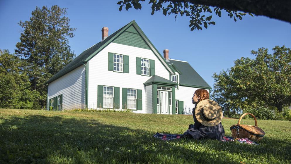 An Anne of Green Gables reenactor poses outside the house