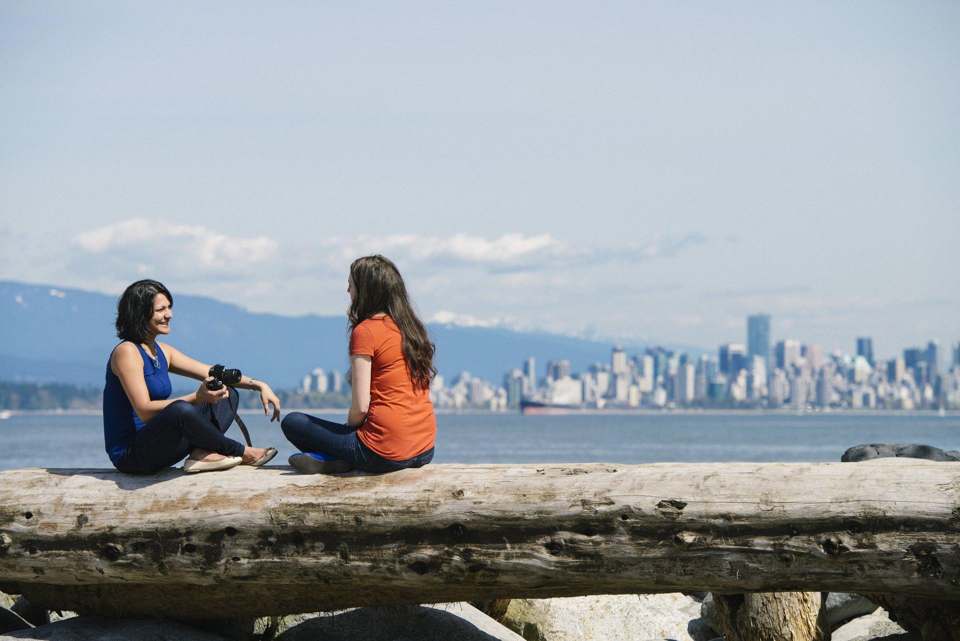 Two people sitting with skyline in background