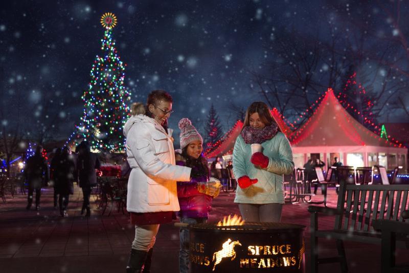 Two people warm up by a fire pit at the international Christmas market in Spruce Meadows