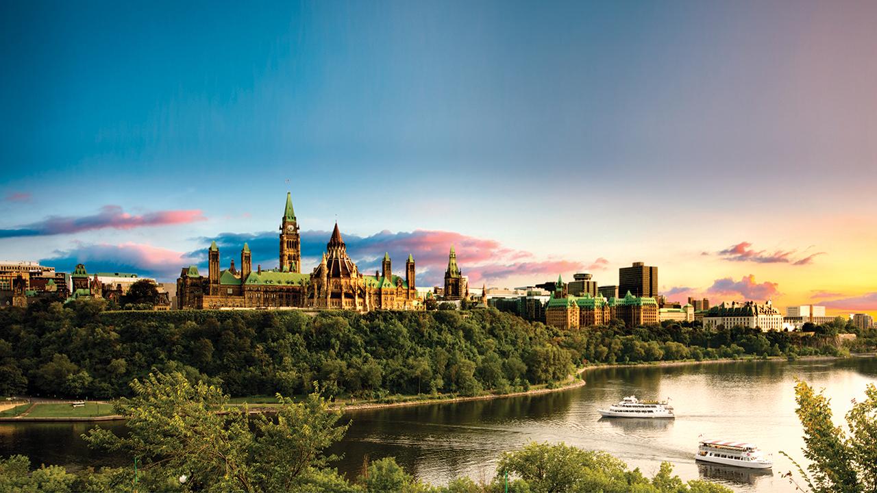 image of Parliament Hill at dusk over the Ottawa River