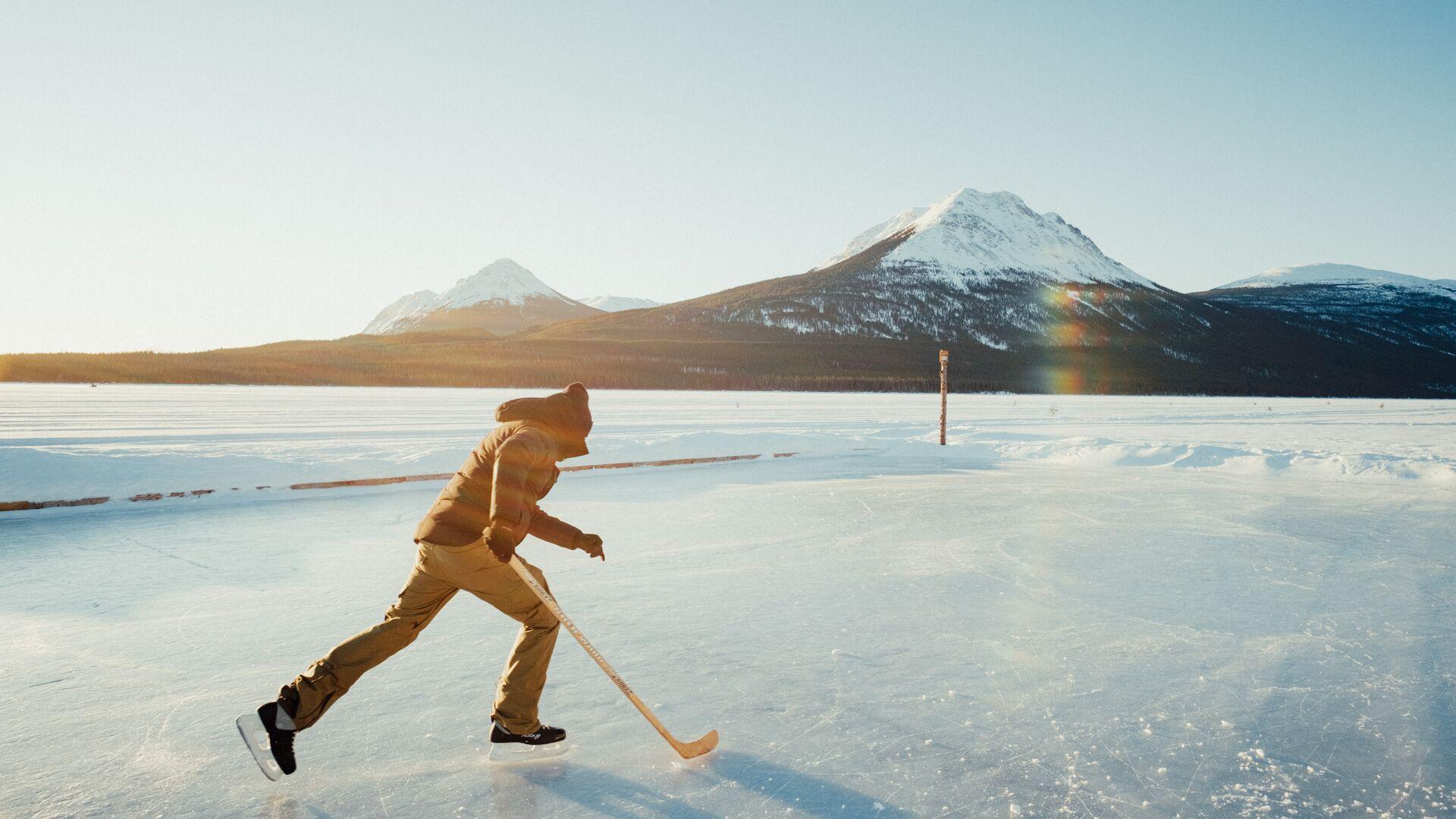 Iceskating on large lake with mountains in the background
