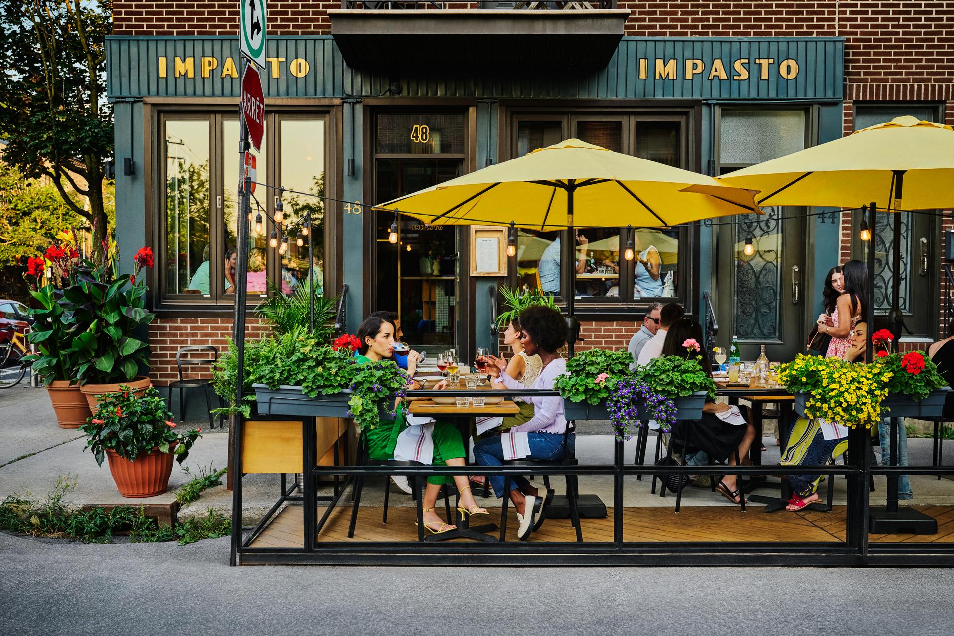 People sitting in an outside restaurant patio under bright yellow umbrellas