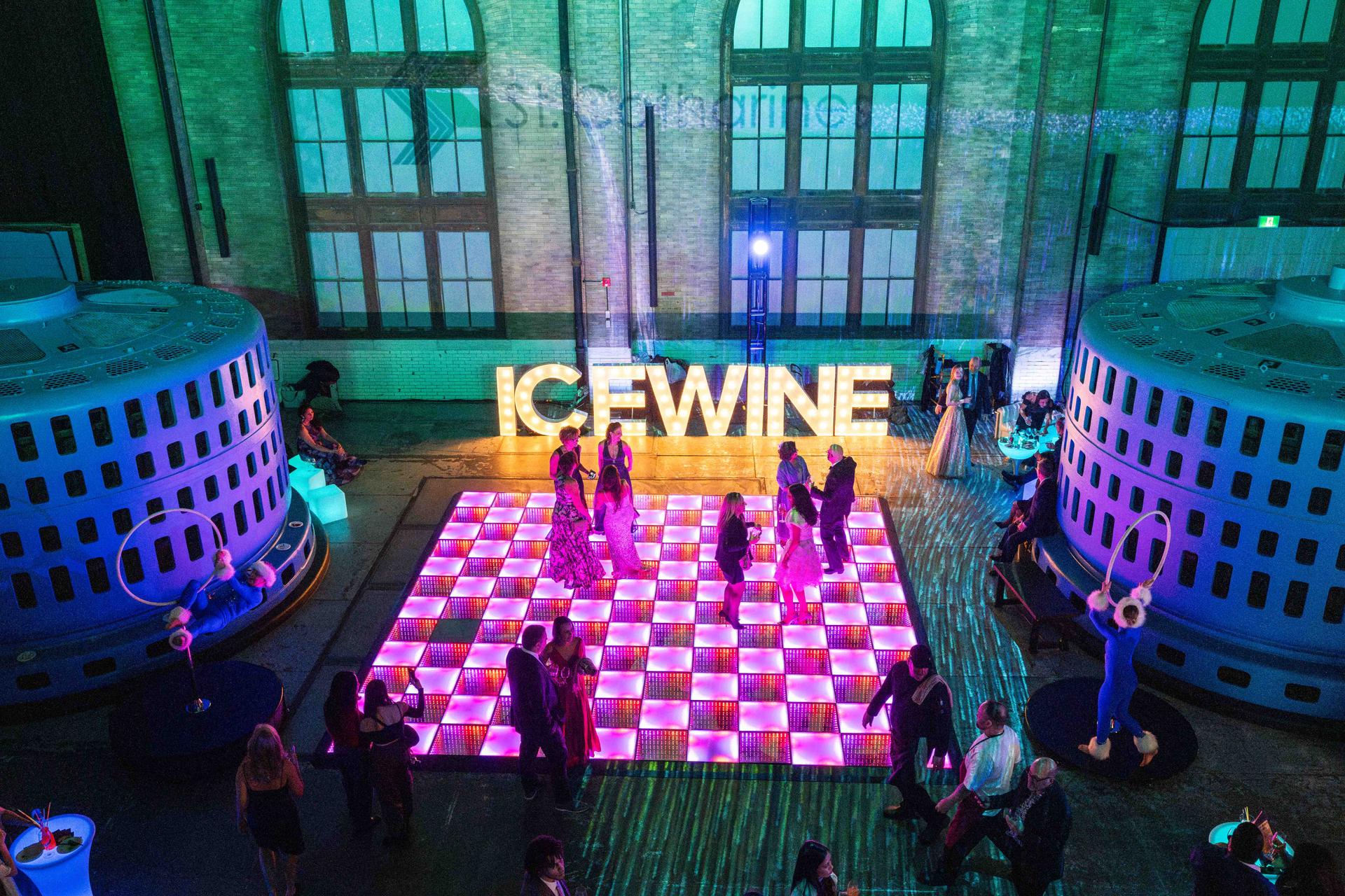 A Niagara Icewine Festival party seen from above, with party-goers dancing on a lit-up checkerboard floor.