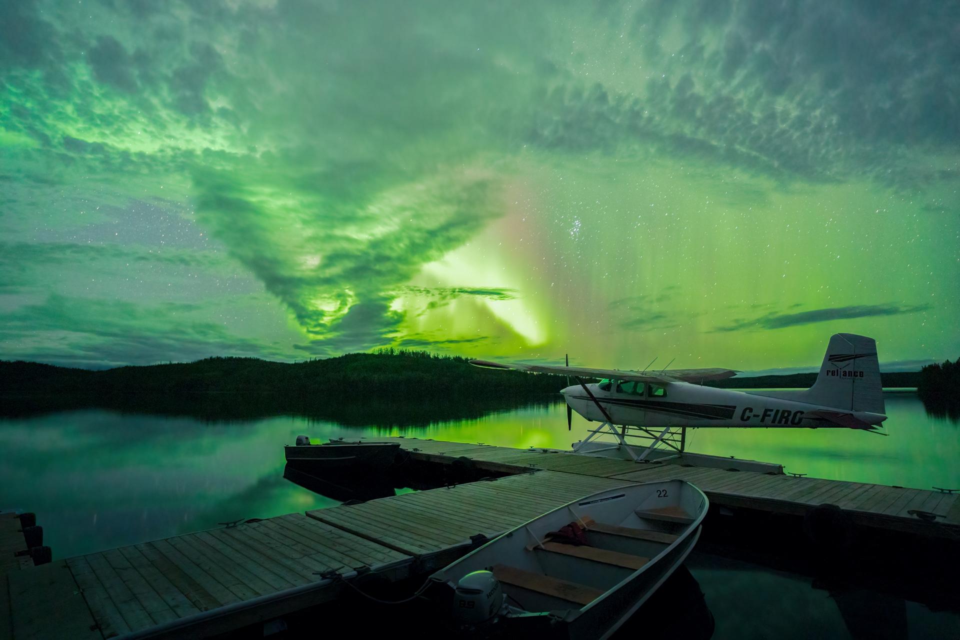 Northern lights reflect over a body of water