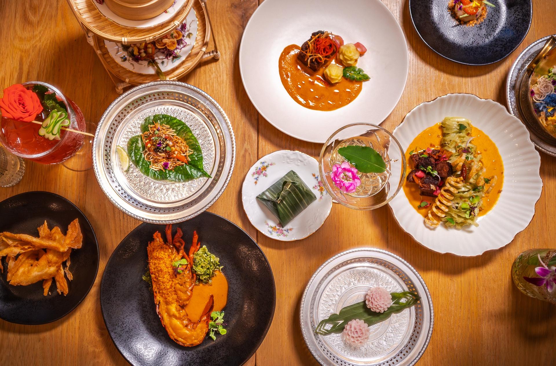 Overhead view of an elegant multi-course meal with colorful plated dishes and drinks