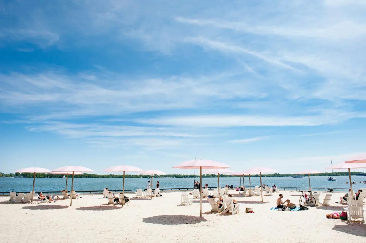 Sugar Beach as a distinctive, man‑made Toronto beach experience—showing the recognizable pink umbrellas and lounging setup that signals ‘no swimming, but big vibes’ for a quick downtown shoreline break.
