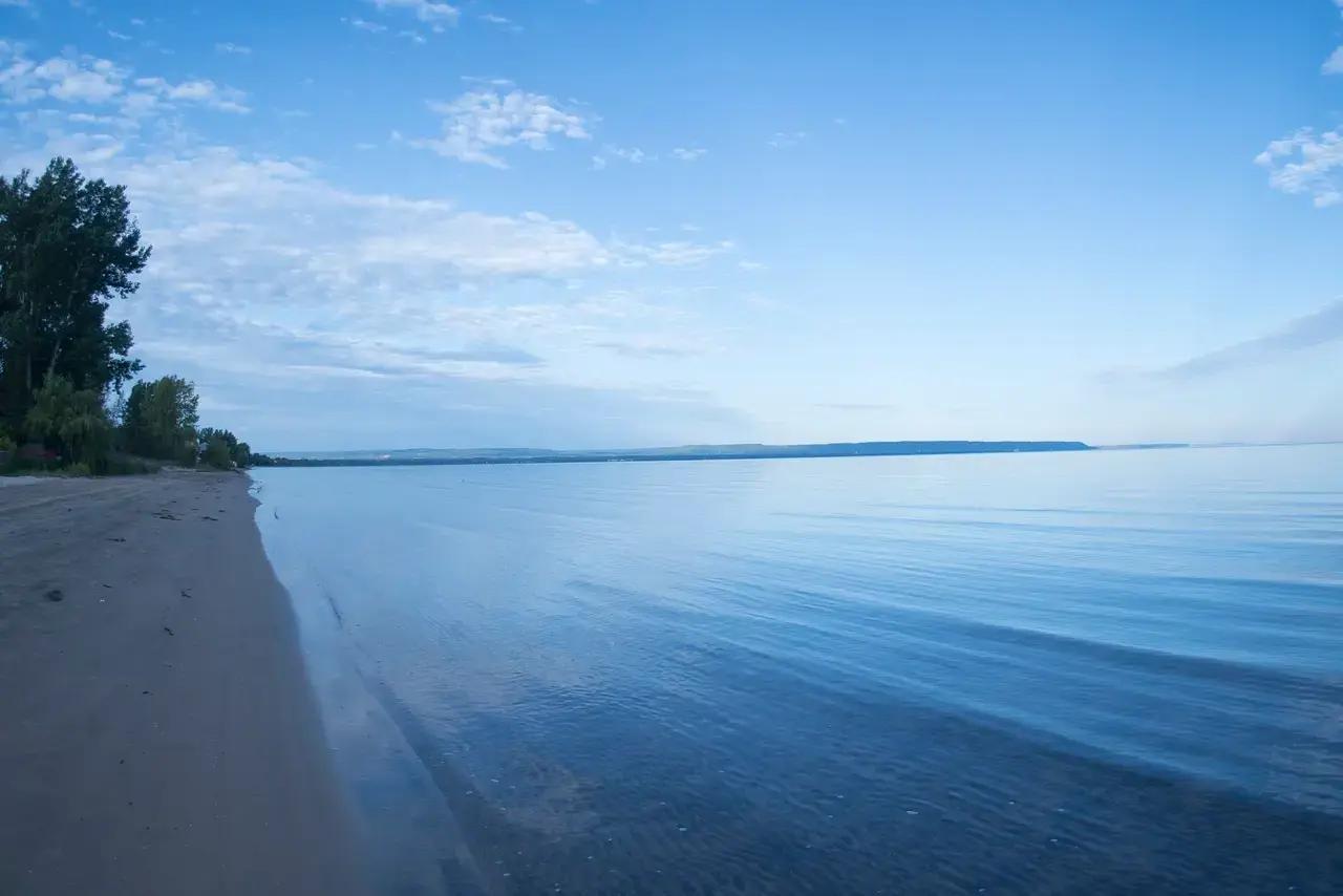 Wasaga Beach stretches nearly 15 kilometres along Georgian Bay at dusk, its shallow waters reflecting soft evening light—illustrating why this Ontario destination is often cited as the world’s longest freshwater beach and a classic summer escape.