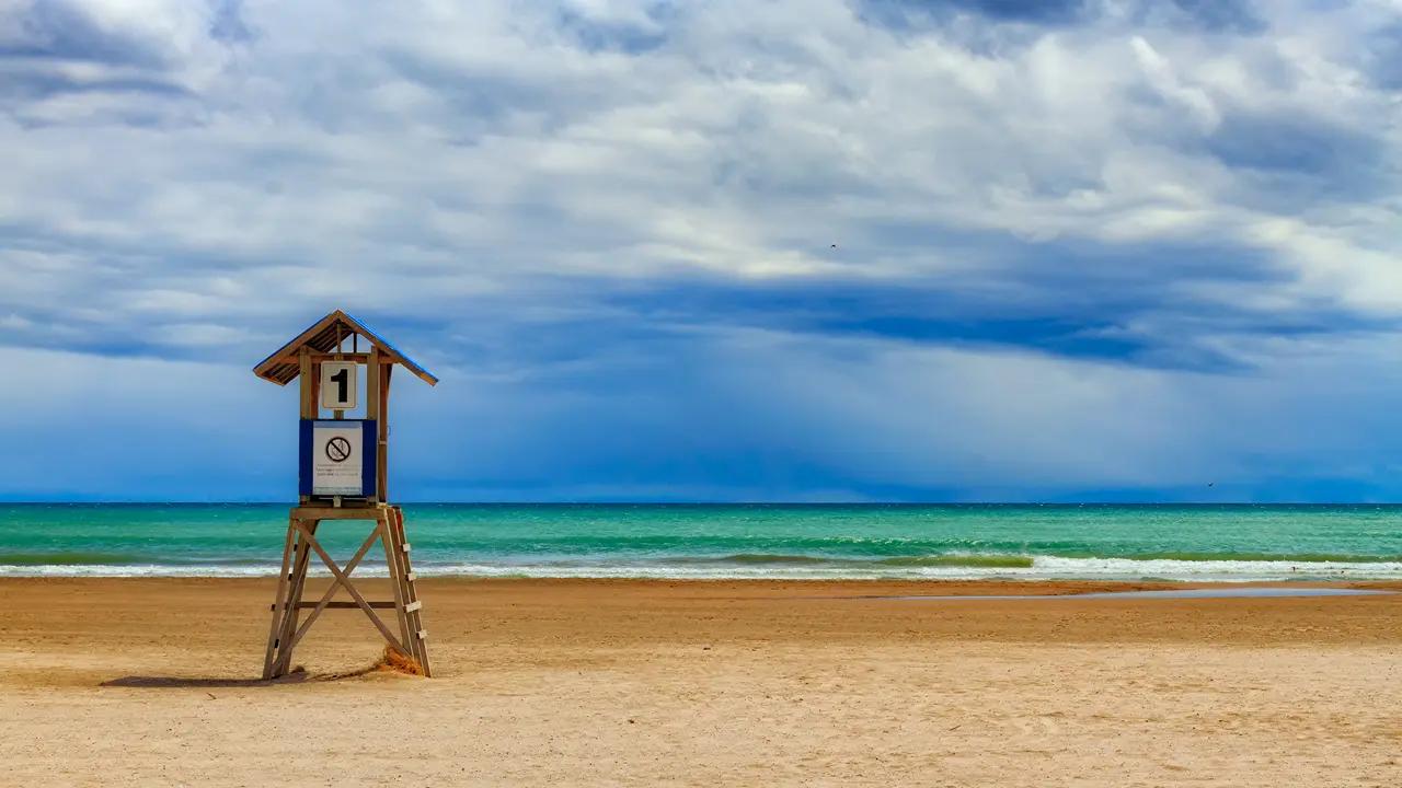Cobourg section image that signals ‘easy day trip beach town’—a simple, iconic lifeguard stand on a broad sandy beach that helps readers map Cobourg as a classic sun-and-sand escape rather than a rugged Great Lakes shoreline.