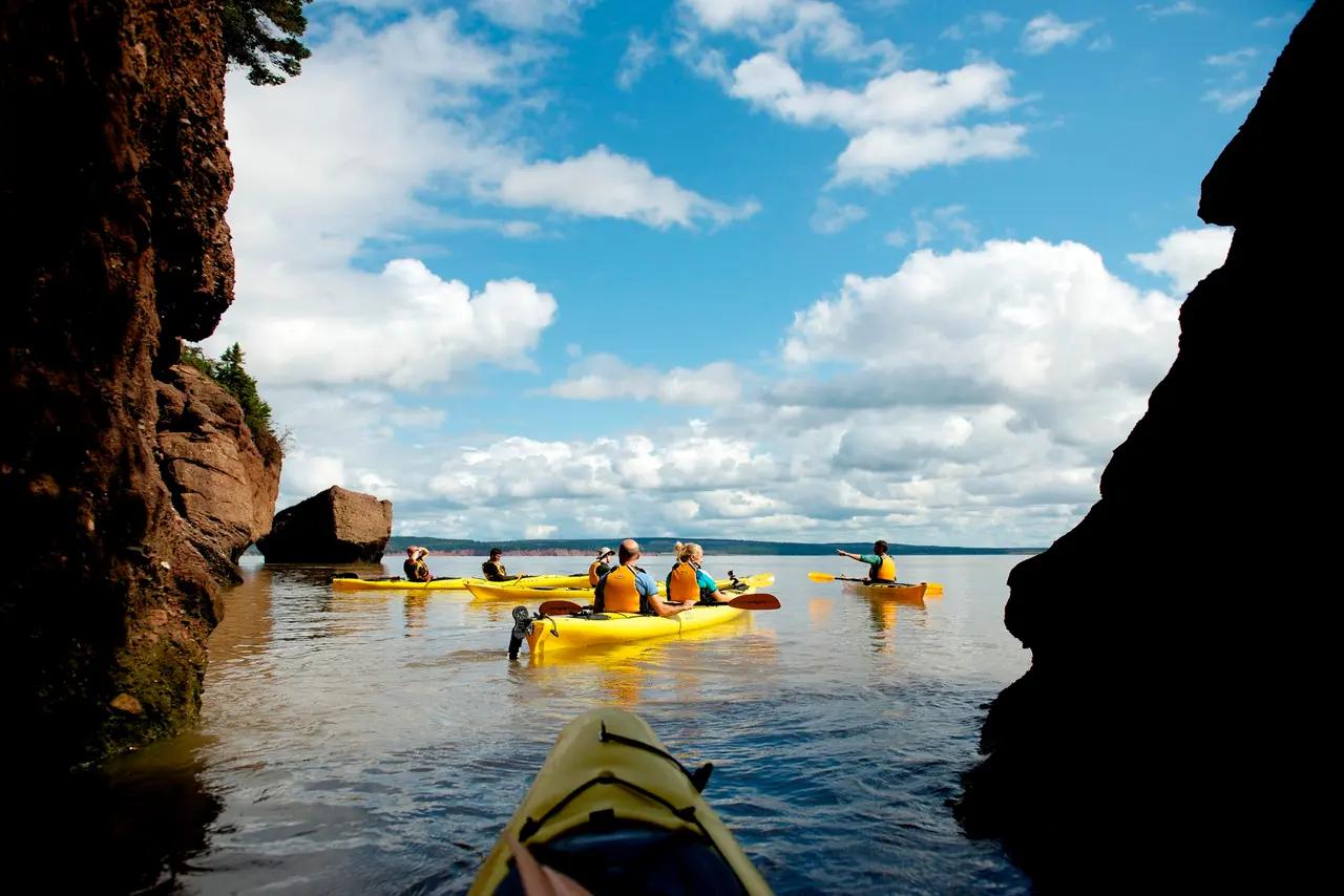 Kayakers navigating the tidal waters around the Hopewell Rocks in New Brunswick, illustrating the article’s ‘water-first’ adventure starting point and why the Bay of Fundy is the anchor for coastal activity planning.