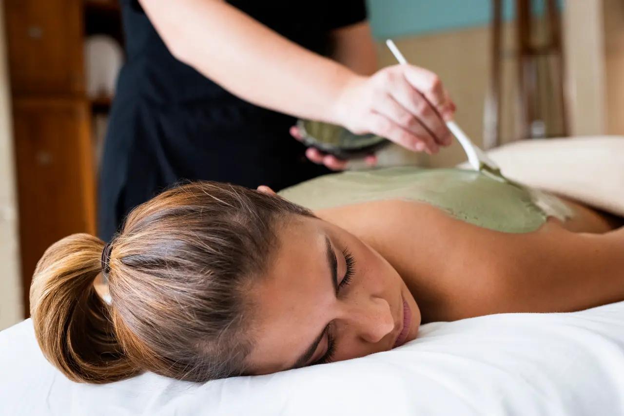 A woman receives a mud body treatment at Fox Harb'r Golf Resort and Spa, where therapists apply mineral-rich clay.