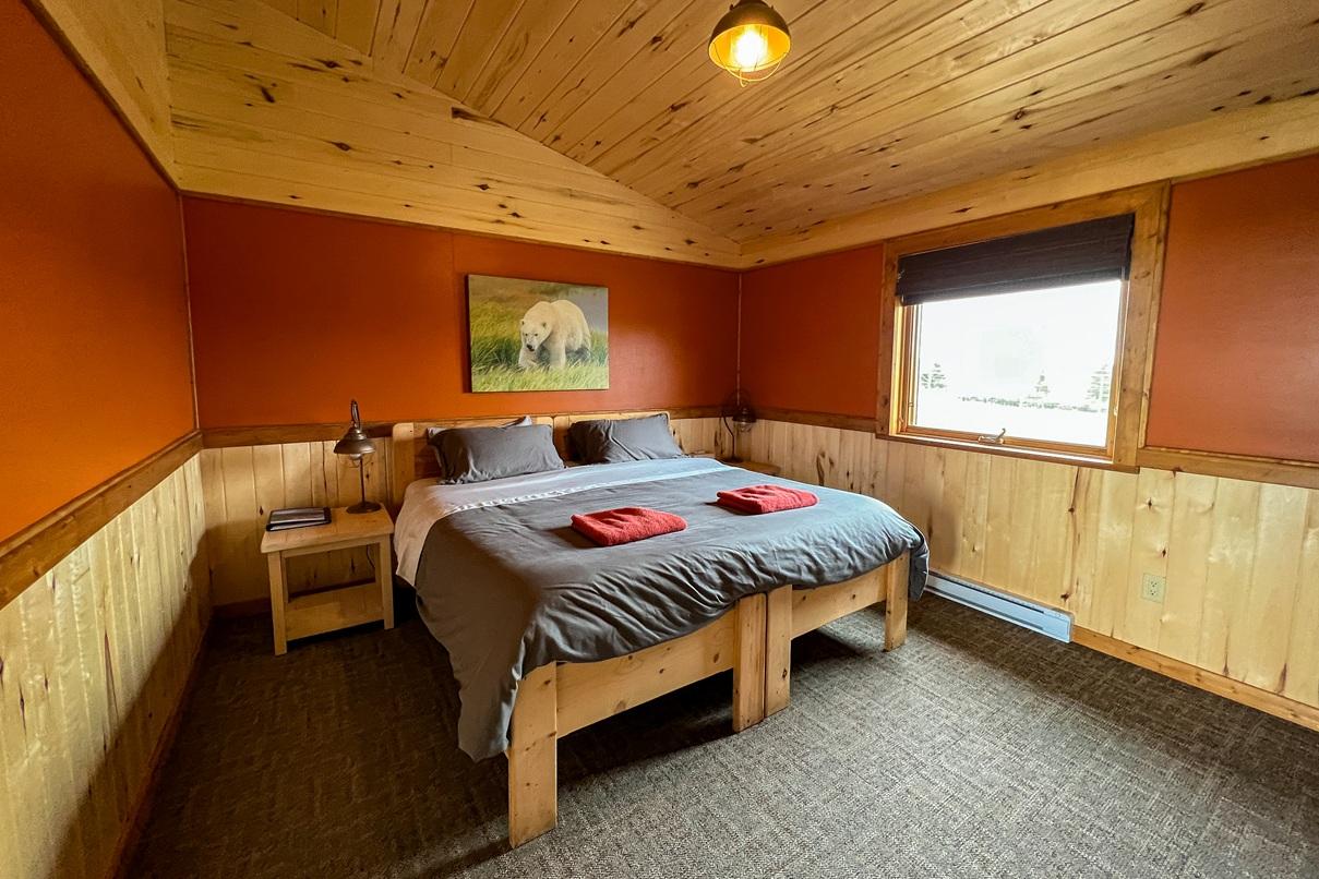 Cozy lodge bedroom with wood panelling and a polar bear photograph