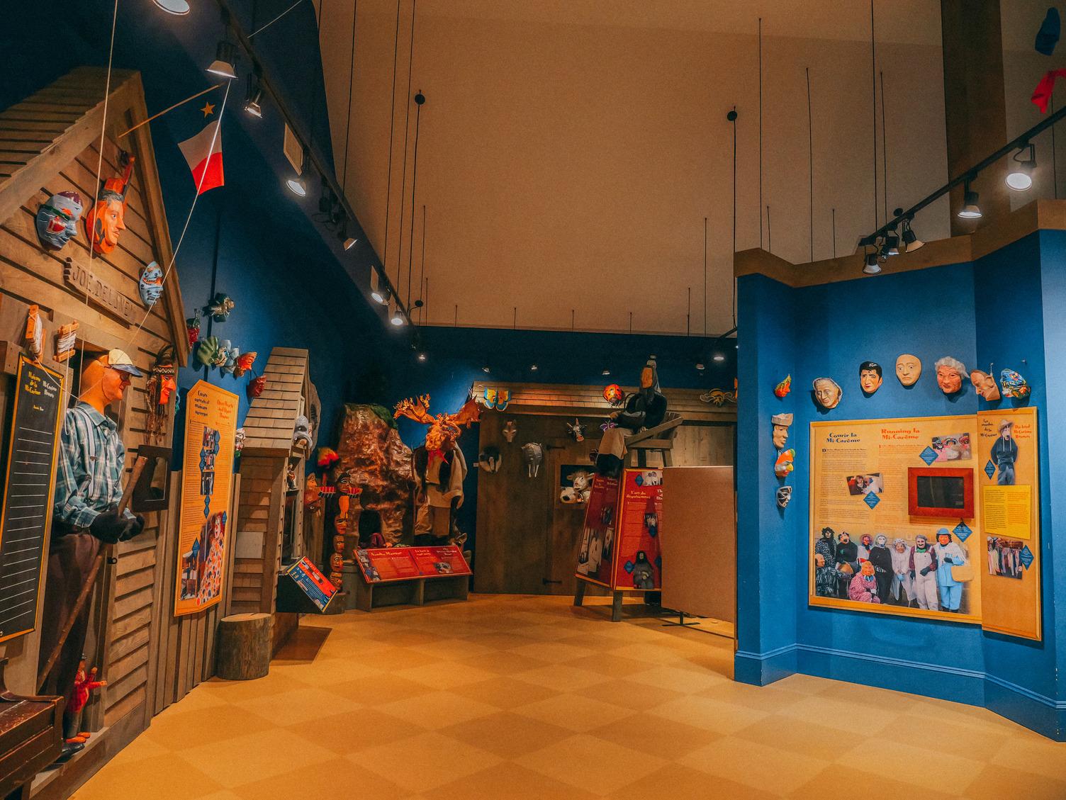 The interior of the Mi-Carême Interpretive Centre in Grand-Étang, its walls lined with brightly coloured handcrafted masks and folk art.