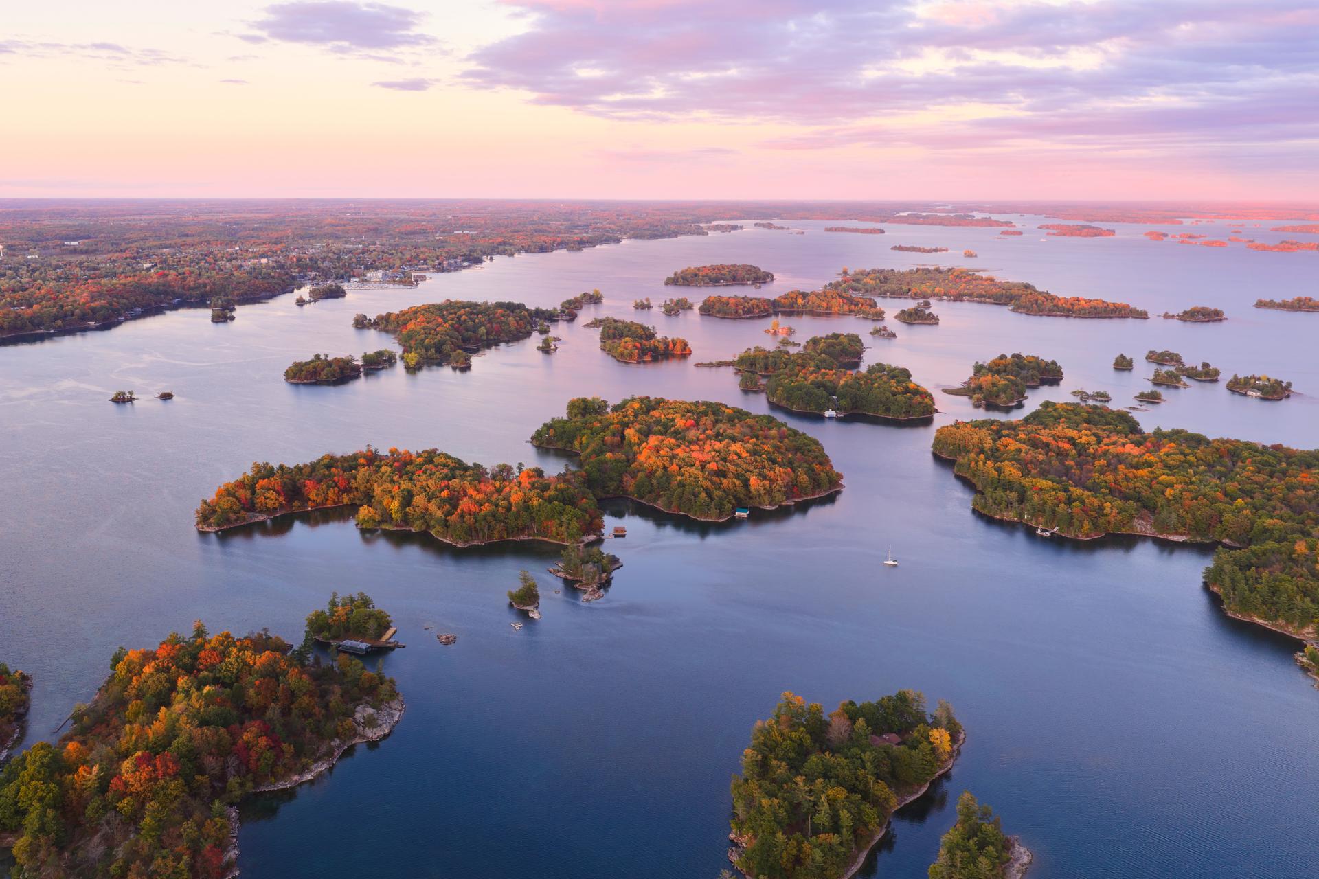 Aerial view of dozens of small tree-covered islands in the St. Lawrence River near the Thousand Islands, Ontario, with fall foliage