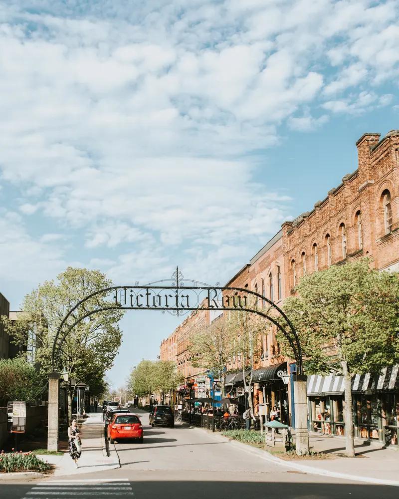 Wrought-iron Victoria Row archway framing the historic brick storefronts in downtown Charlottetown, Prince Edward Island