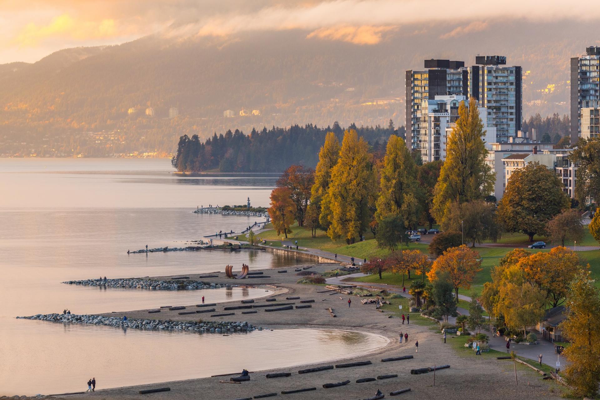 Waterfront park surrounded by autumn trees and city buildings