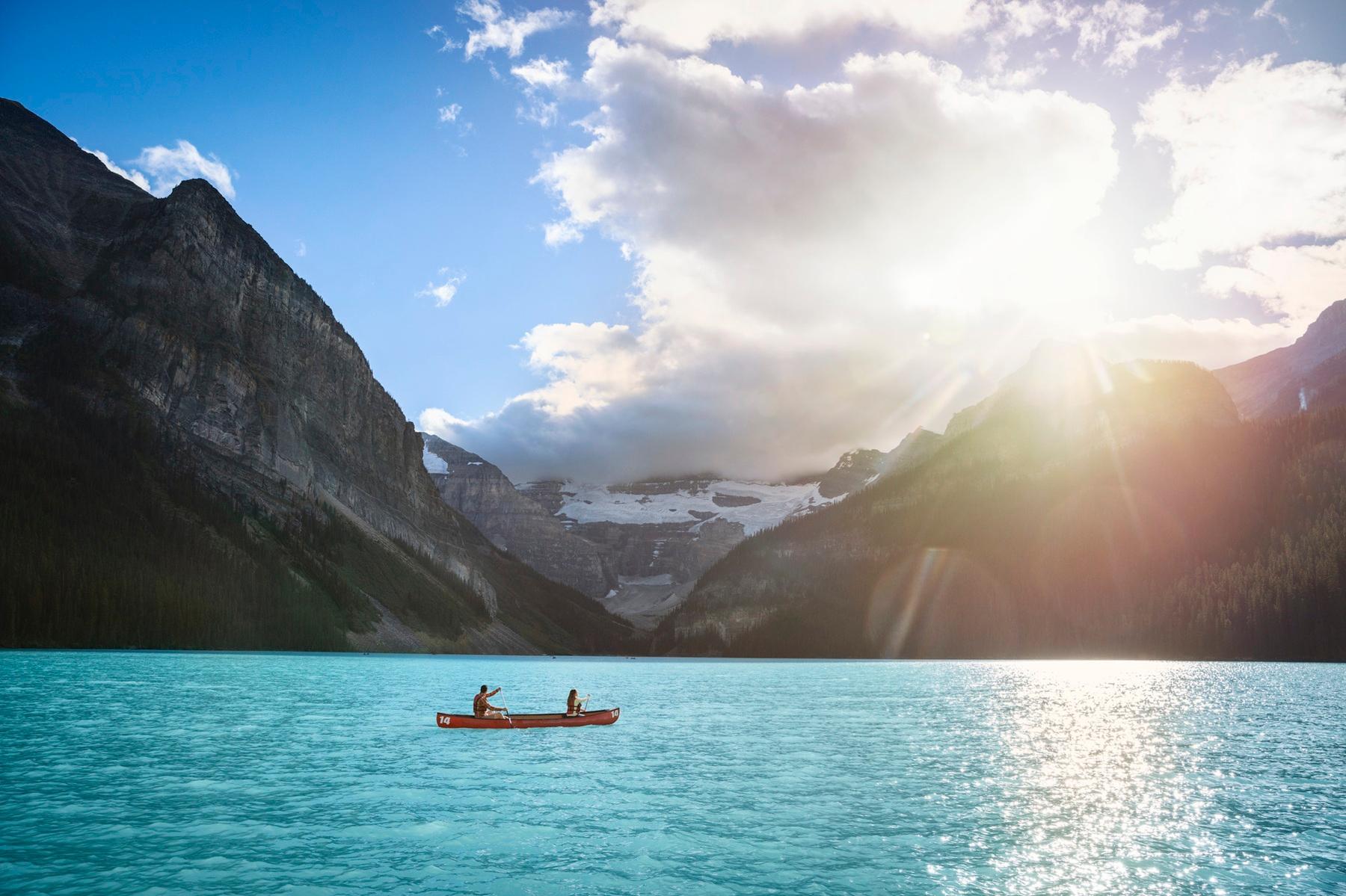 People canoeing on a turquoise mountain lake