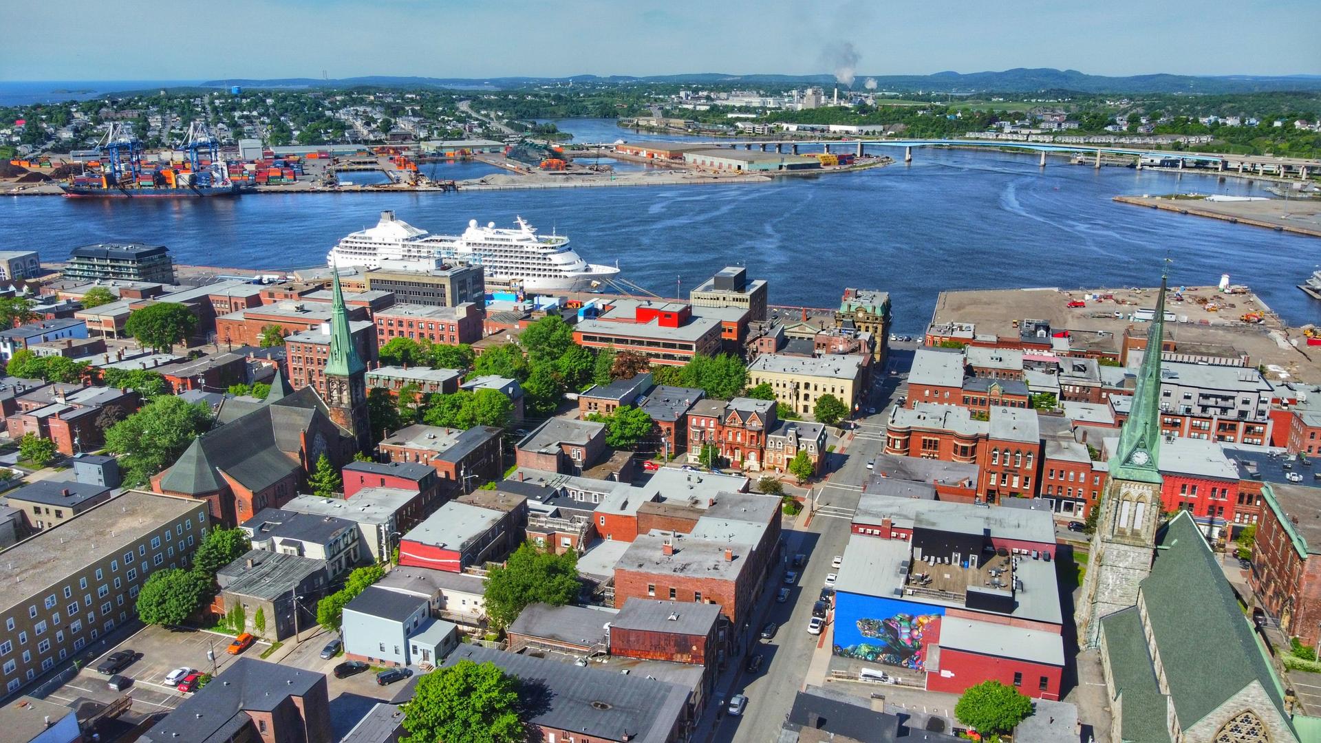 Aerial view of uptown Saint John, New Brunswick, with historic brick buildings and church spires above the harbour on the Bay of Fundy.