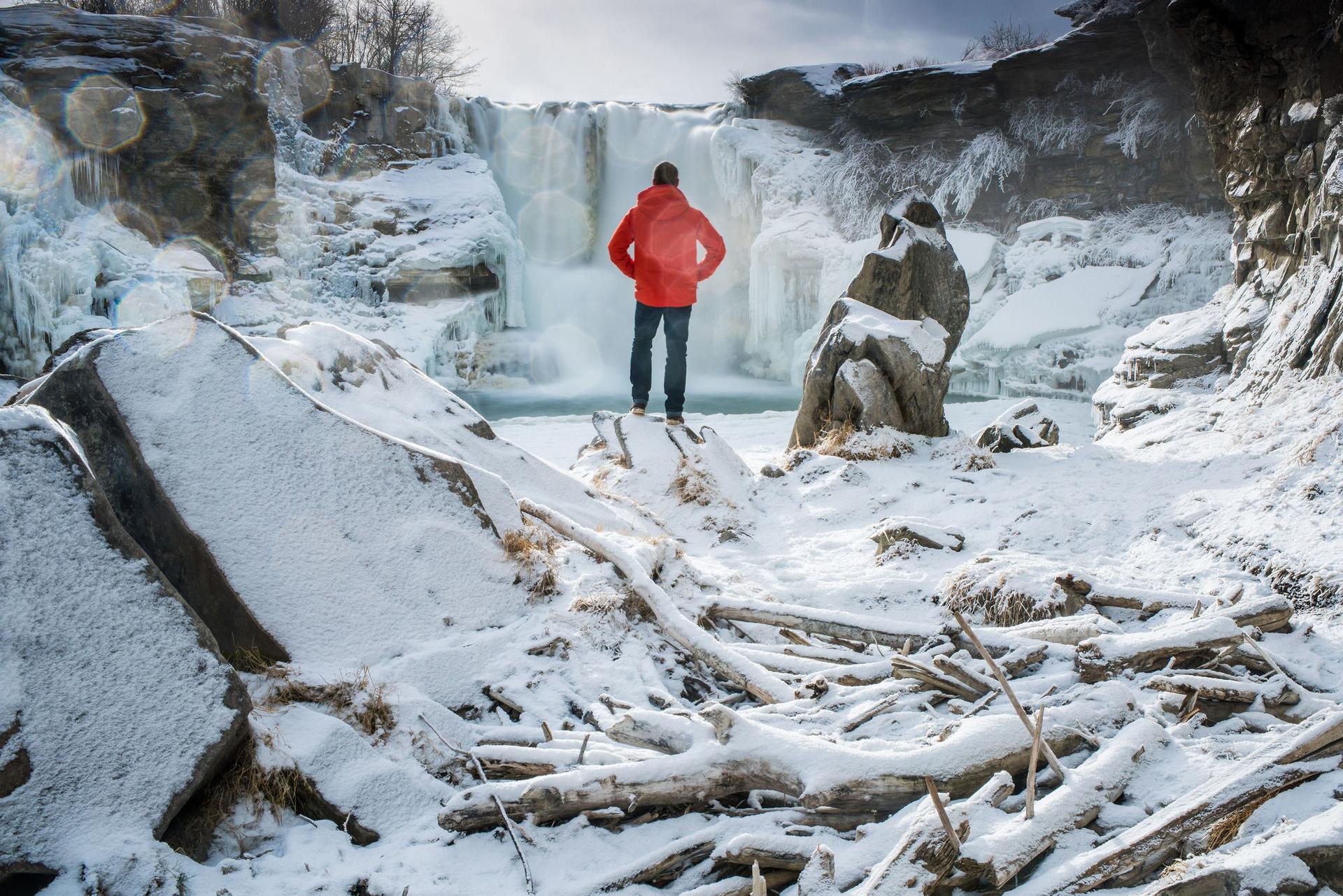person viewing frozen waterfall in winter in Alberta