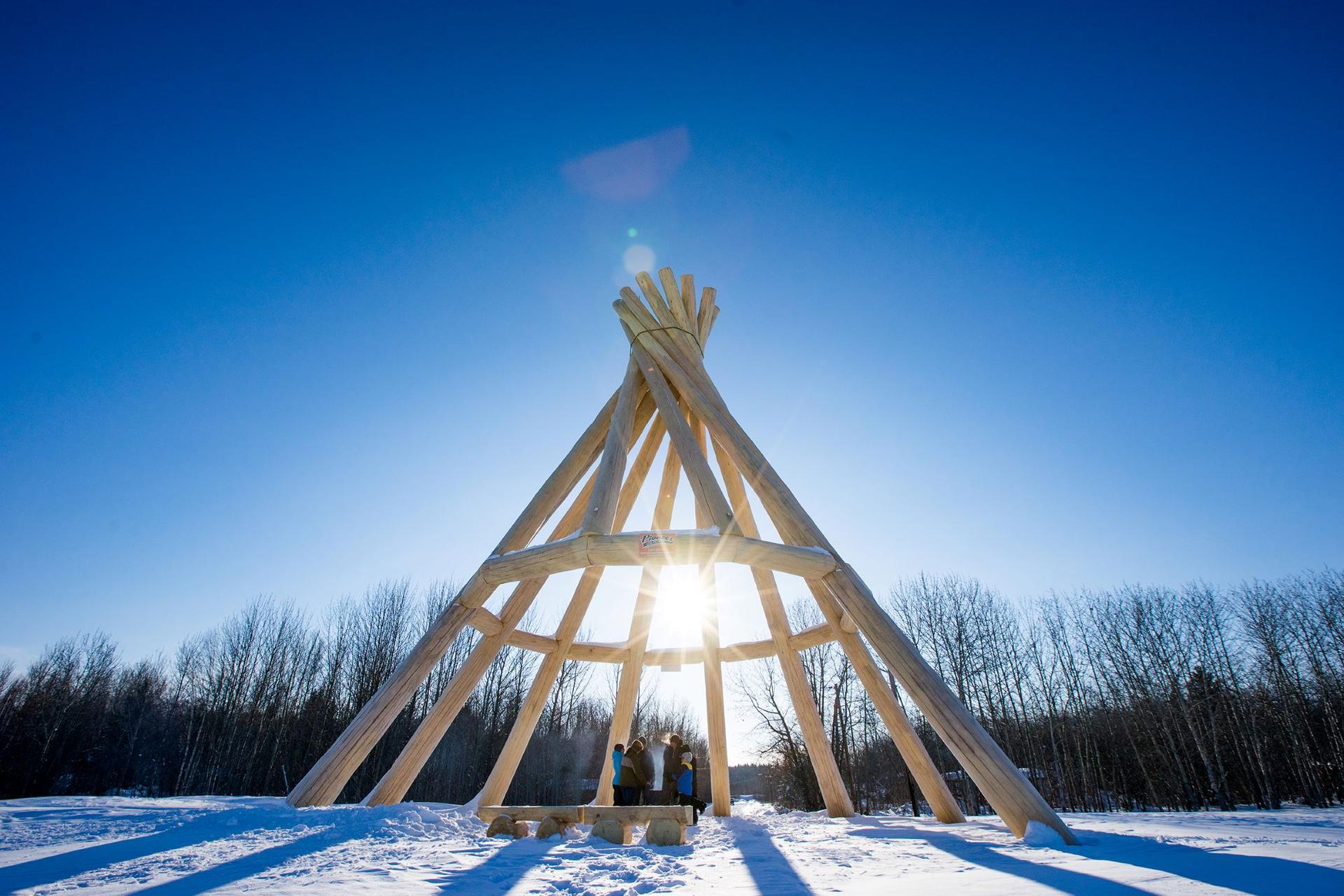 the world's tallest wooden teepee outside with blue sky 