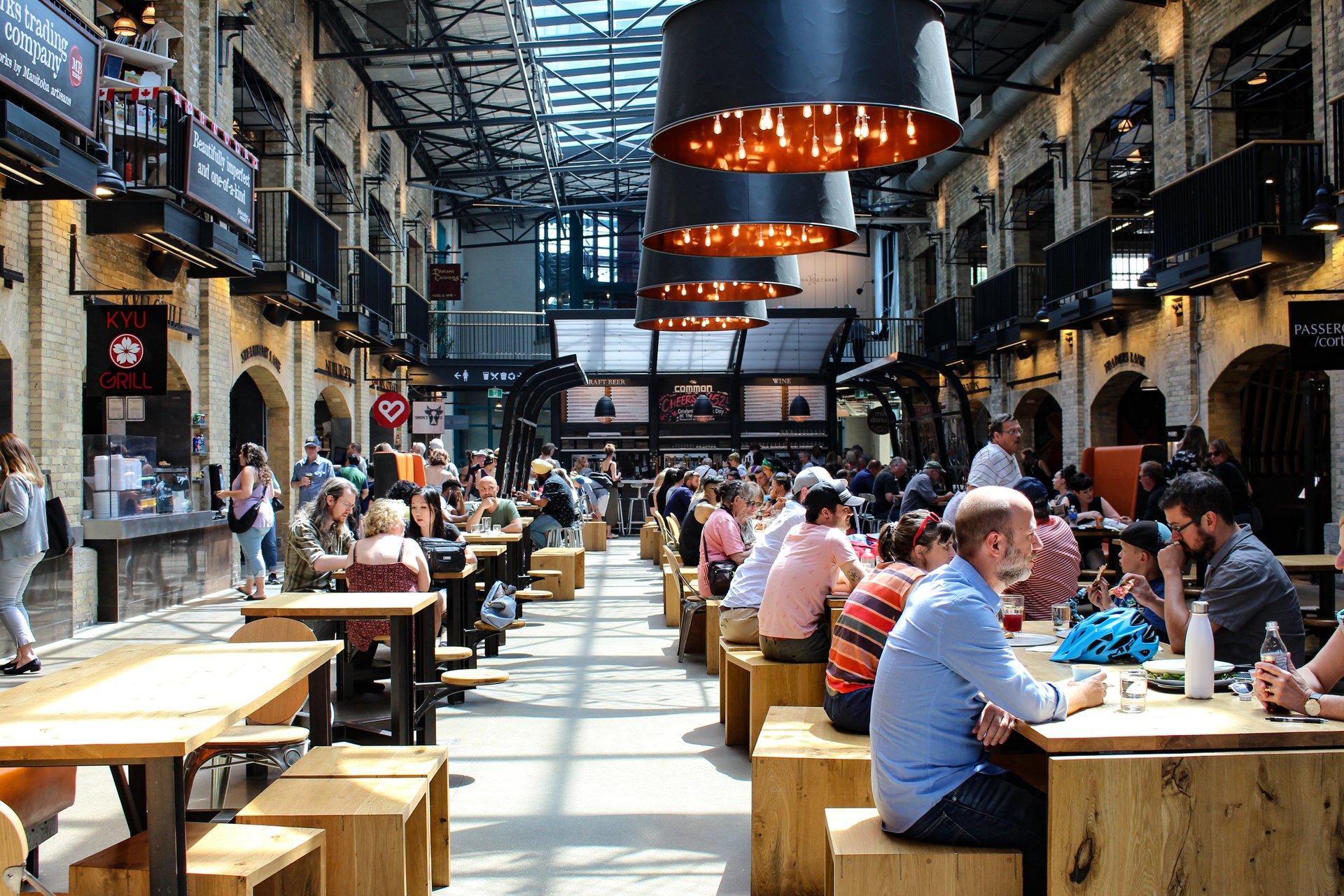 people eating and chatting inside at the Forks market food hall