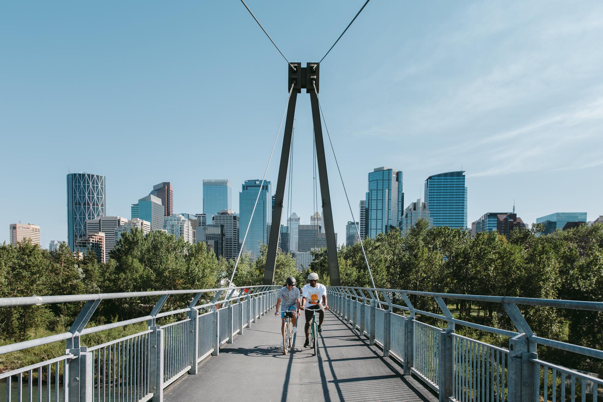 Photo of people cycling across Prince’s Island Bridge in Calgary, Alberta