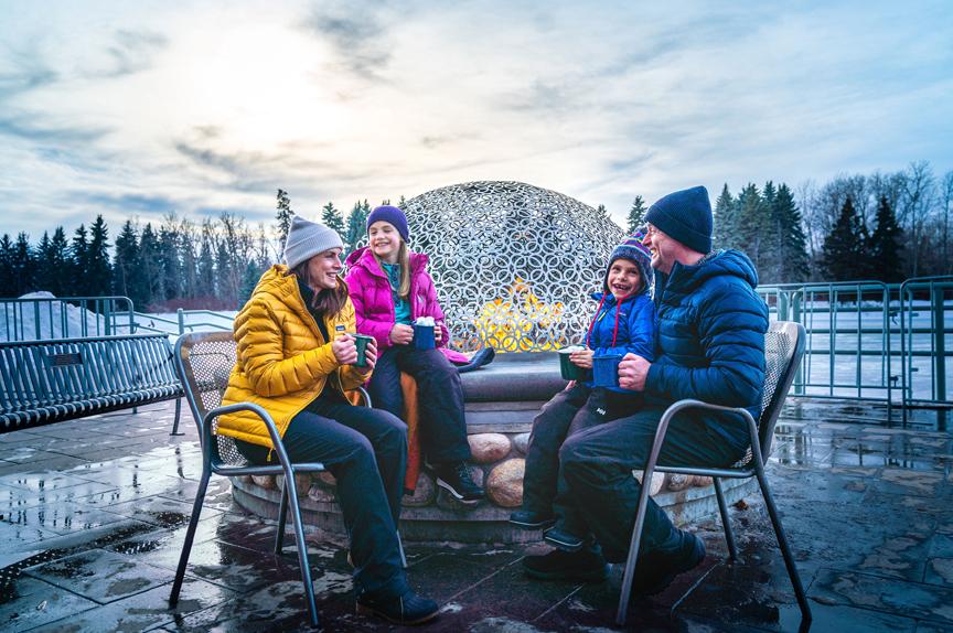 people sitting beside a cozy fire by a lake 
