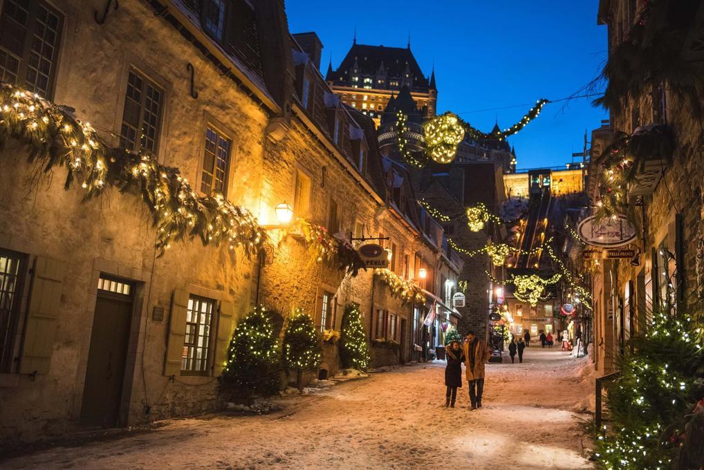two people walking the snowy cobblestone streets of old quebec