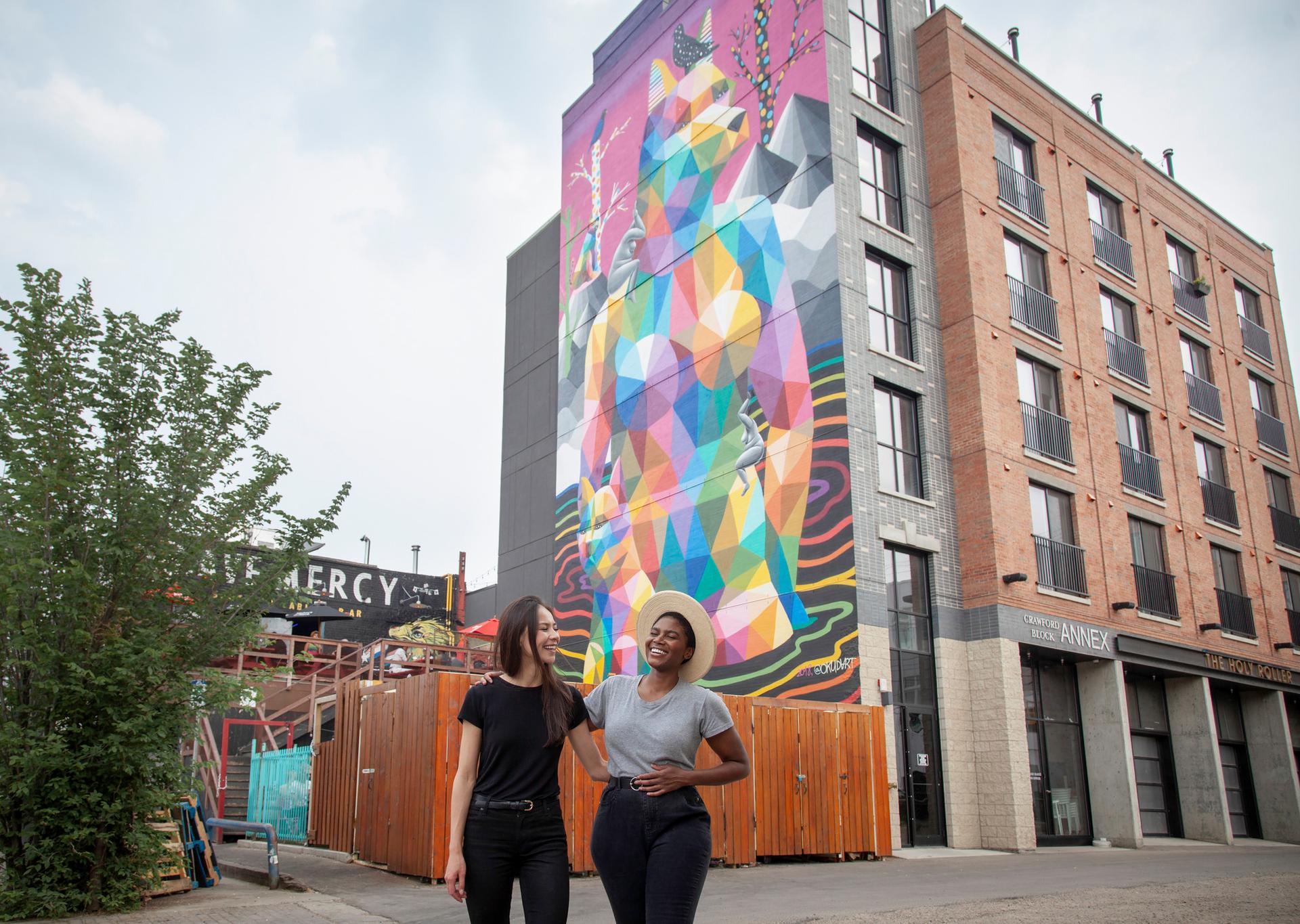 people standing in front of a mural in edmonton