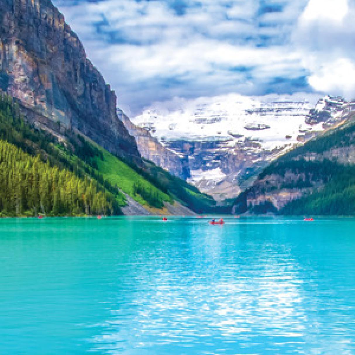 Mountains and green forest surround a turquoise blue lake 