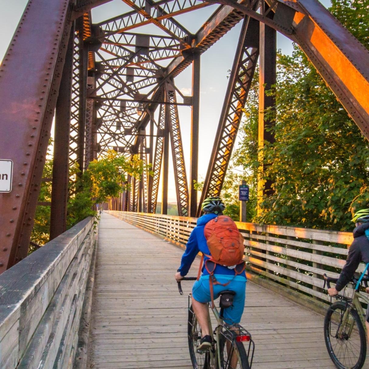Two cyclists cross the Saint John River bridge in Fredericton